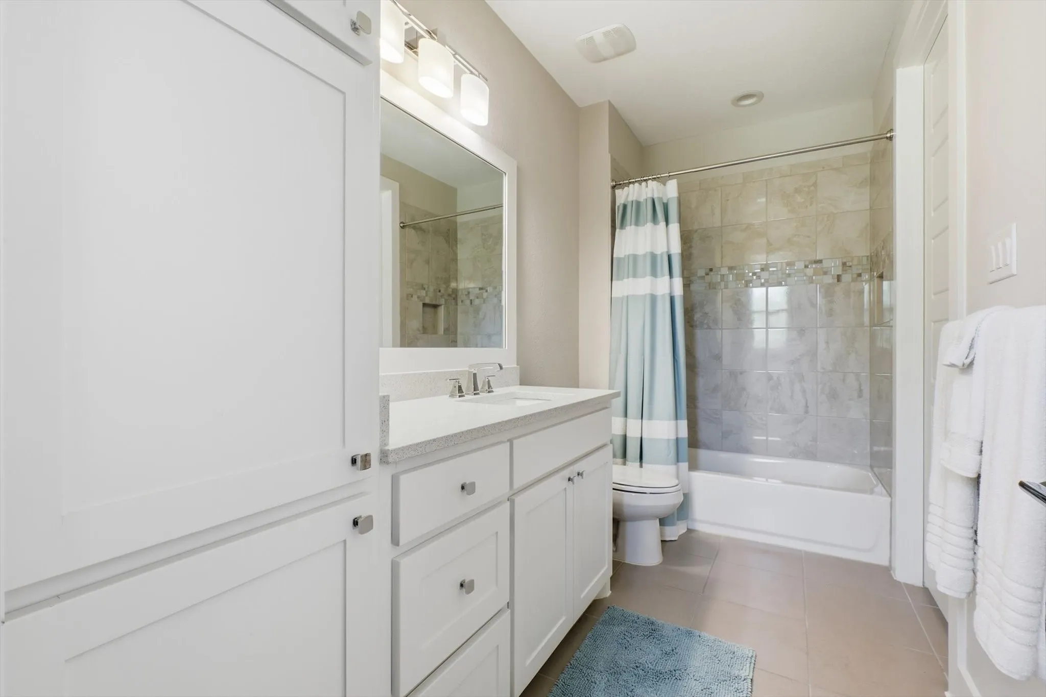 Guest bath with tub/shower combo, quartz counter and beautiful tile surround.