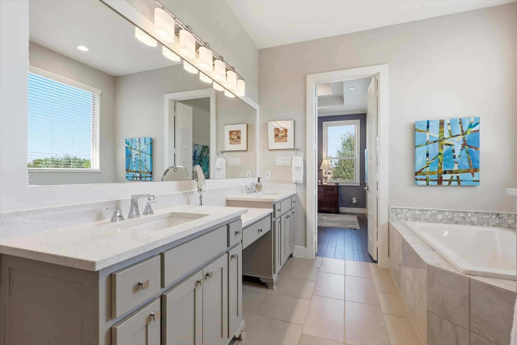 Double sinks and vanity area with plenty of storage.  Gorgeous tile work!