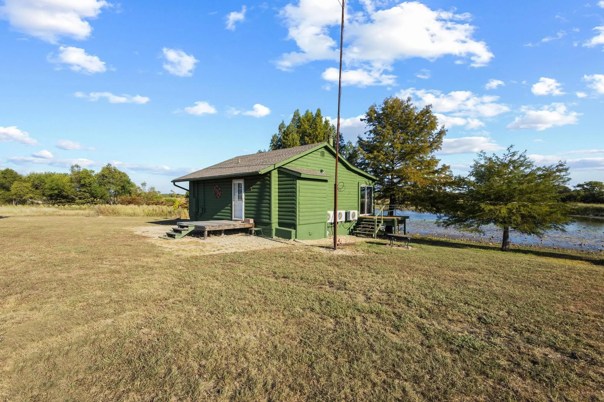 Cabin sits comfortably at the edge of the large pond