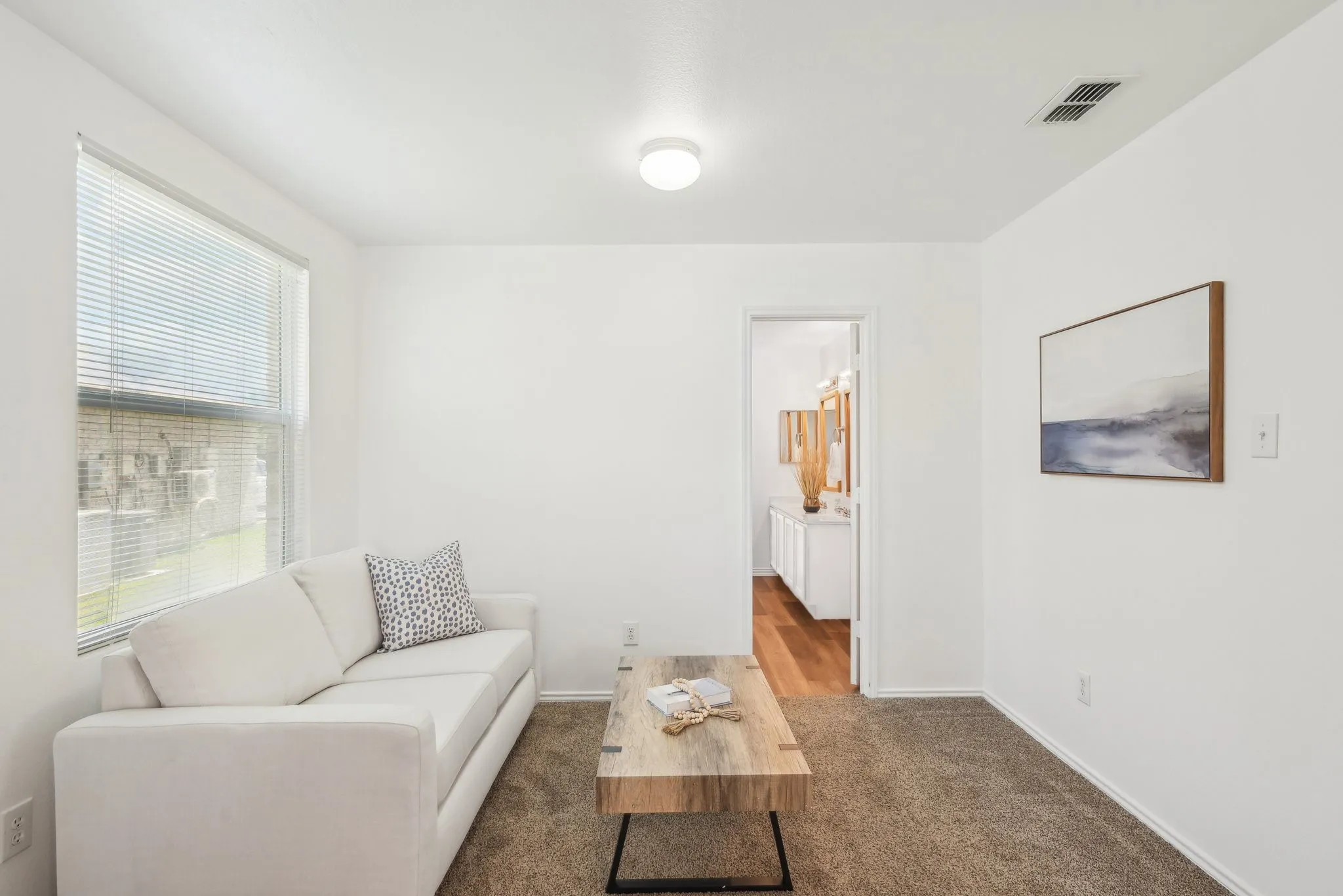 Living area with dark colored carpet and baseboards