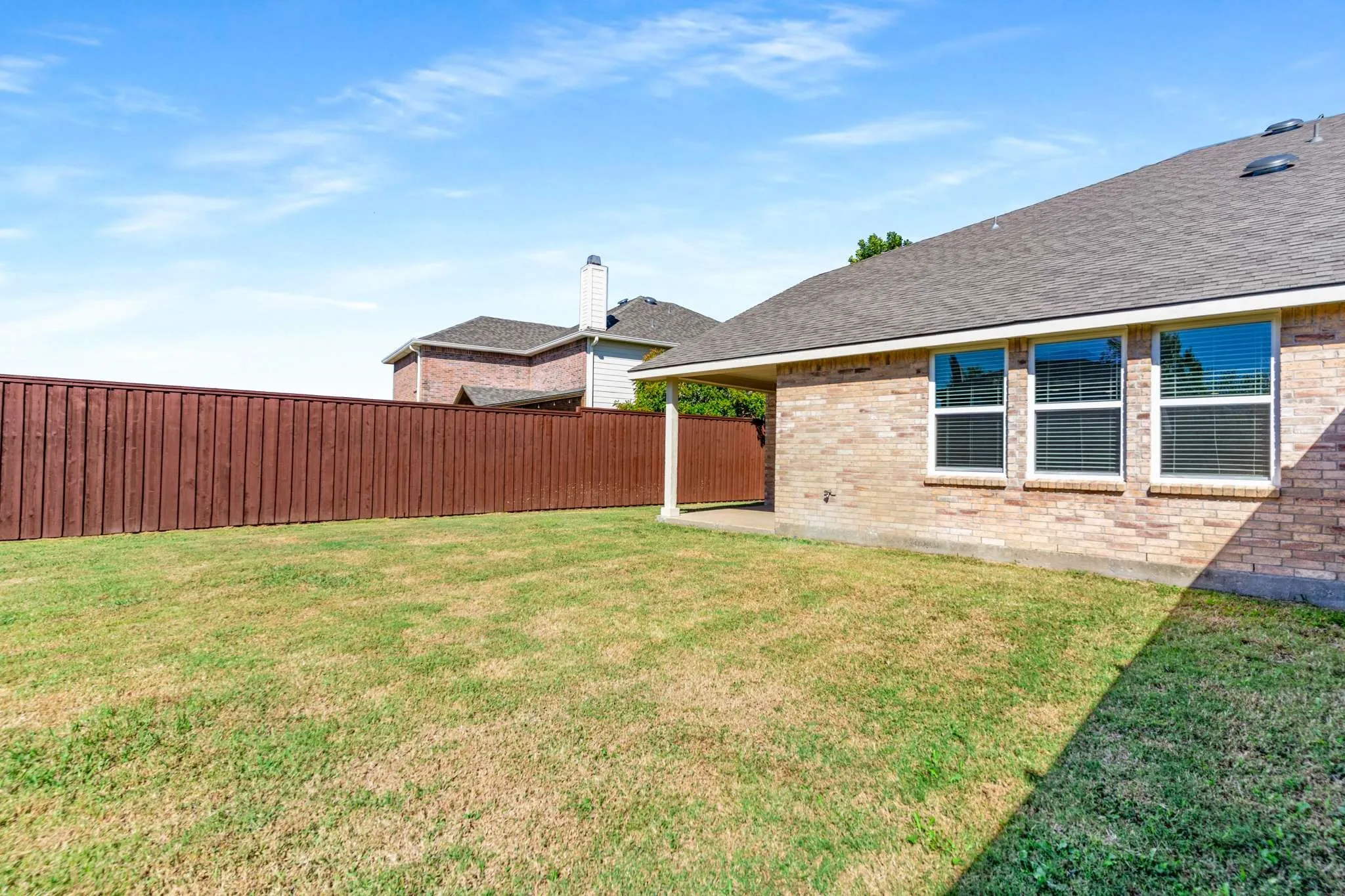 Fenced backyard with a patio