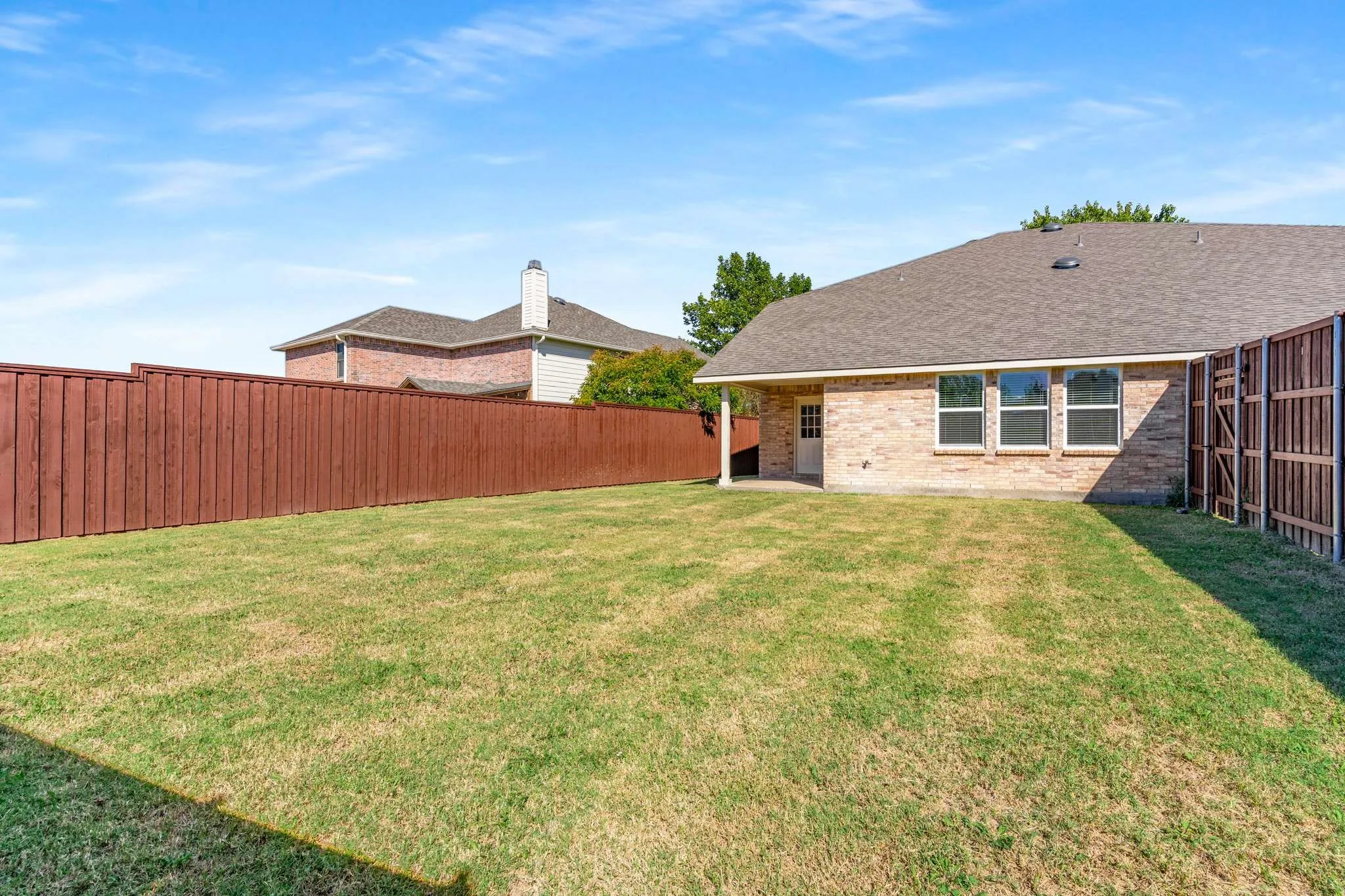 Fenced backyard with a patio