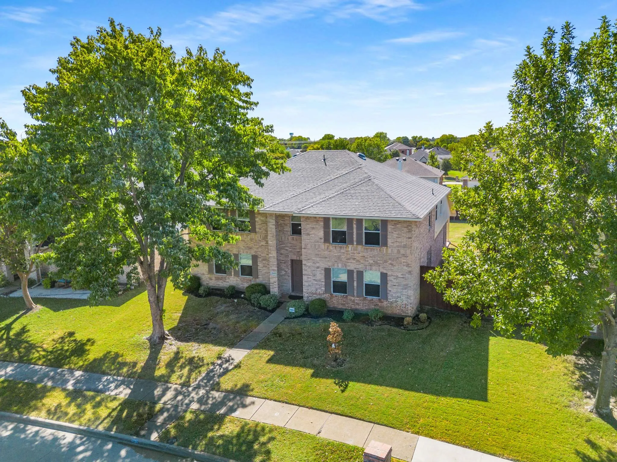 View of front of house featuring a front yard, stone siding, and brick siding