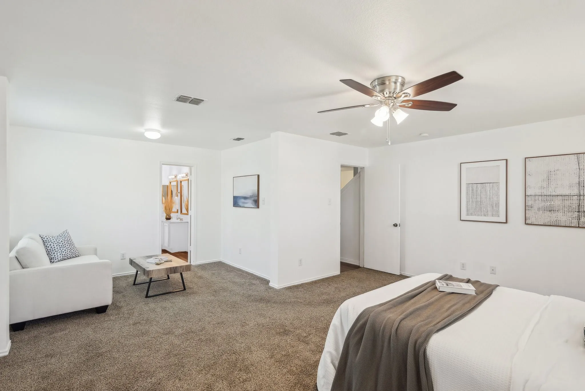 Carpeted bedroom with a ceiling fan and ensuite bath