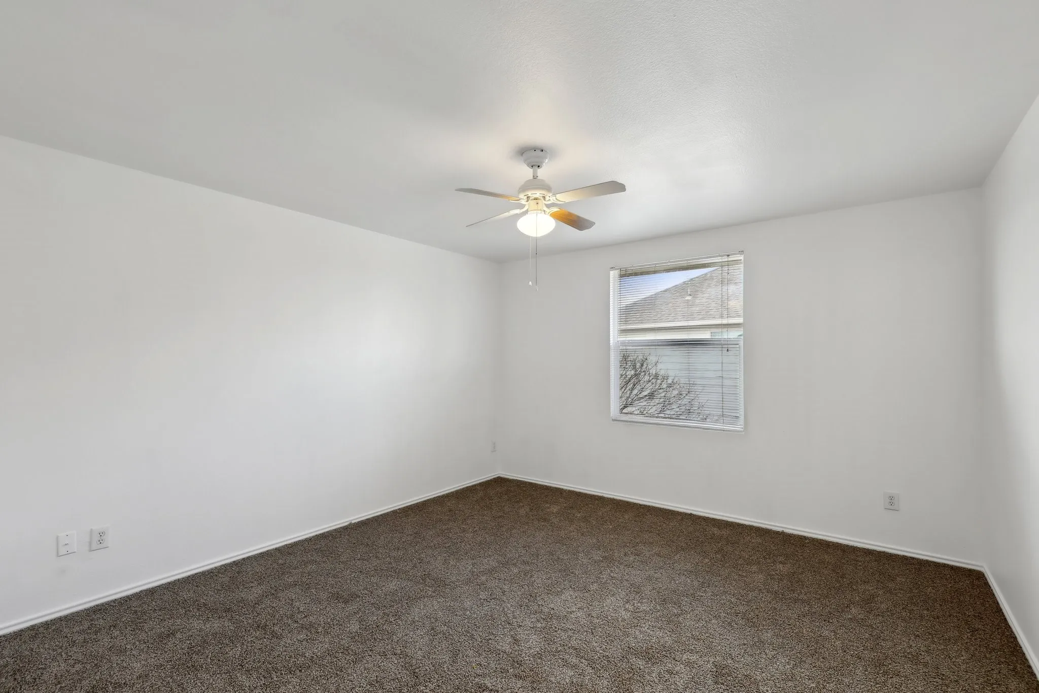 Unfurnished room featuring dark colored carpet and ceiling fan