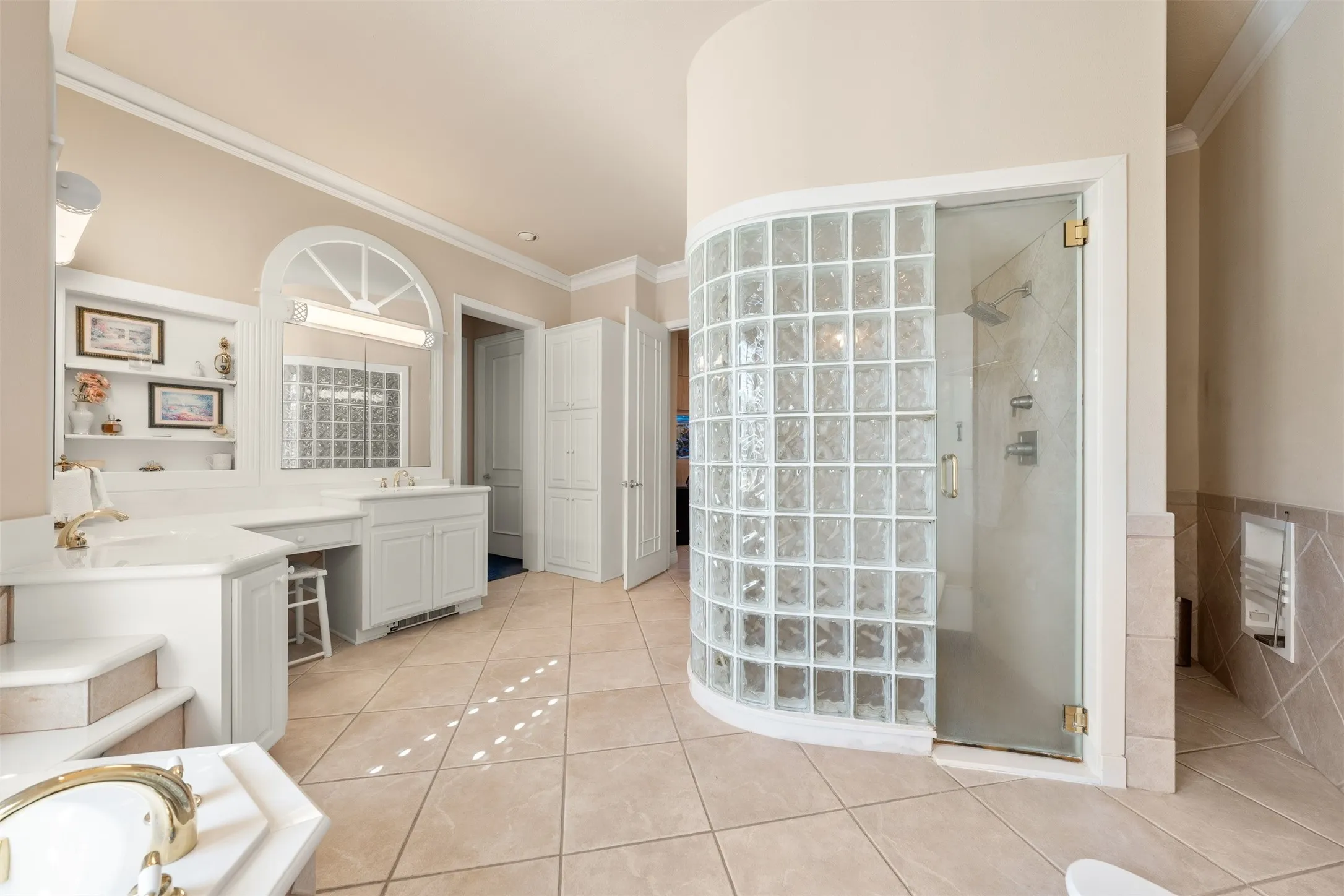 Full bathroom with ornamental molding, light tile patterned floors, vanity, a shower stall, and a tub
