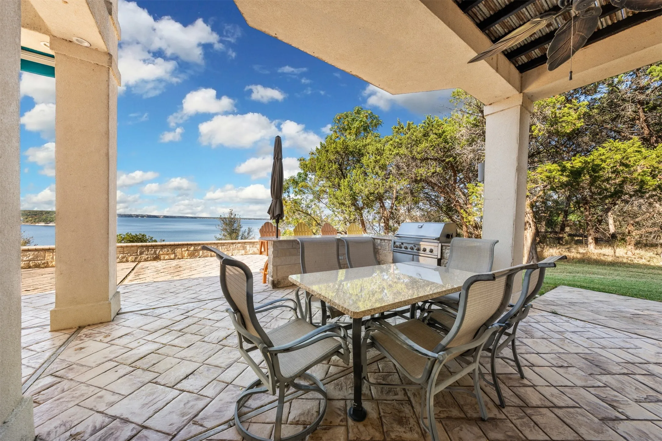 View of patio / terrace with outdoor dining space, a water view, and an outdoor kitchen
