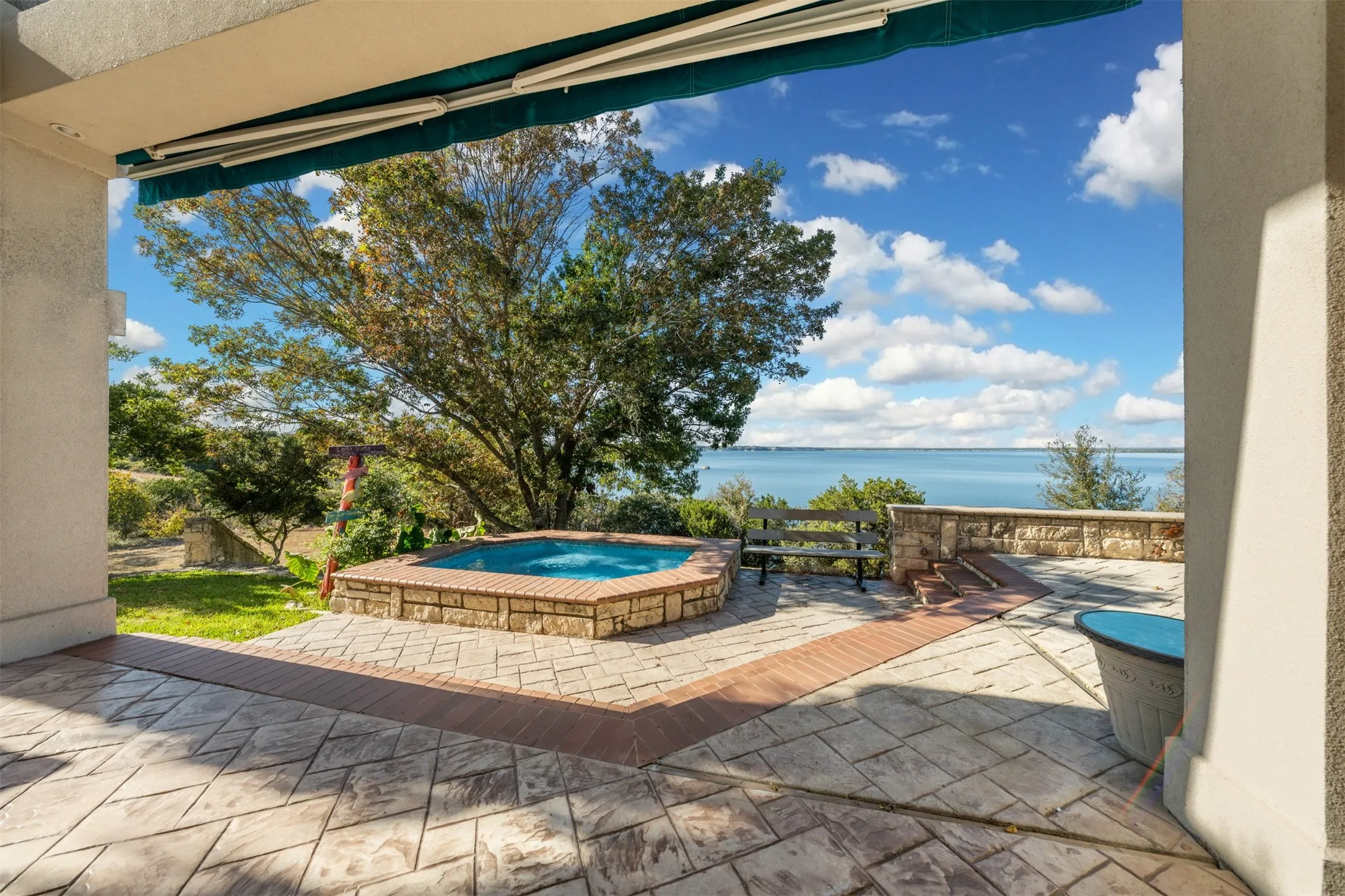 View of patio / terrace featuring an outdoor hot tub and a water view