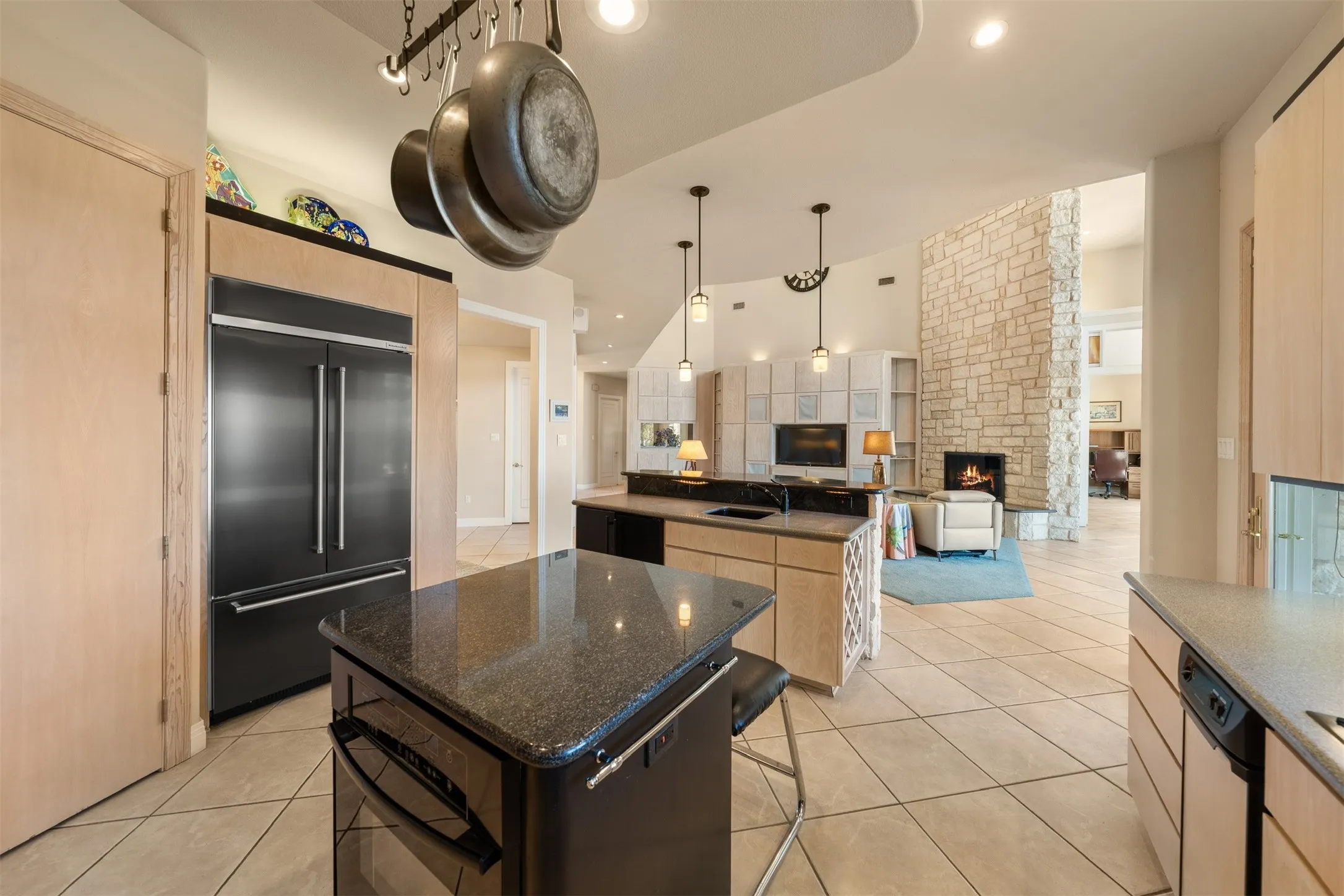 Kitchen featuring light tile patterned floors, built in refrigerator, light brown cabinets, oven, and recessed lighting