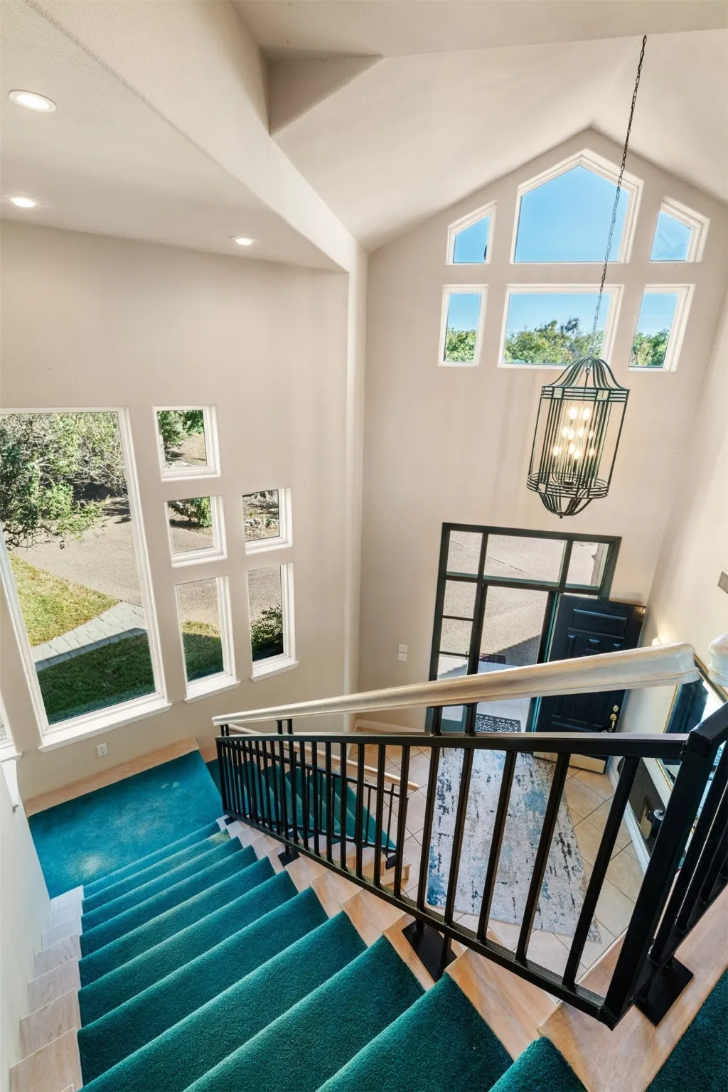 Stairs featuring high vaulted ceiling, a chandelier, and wood finished floors