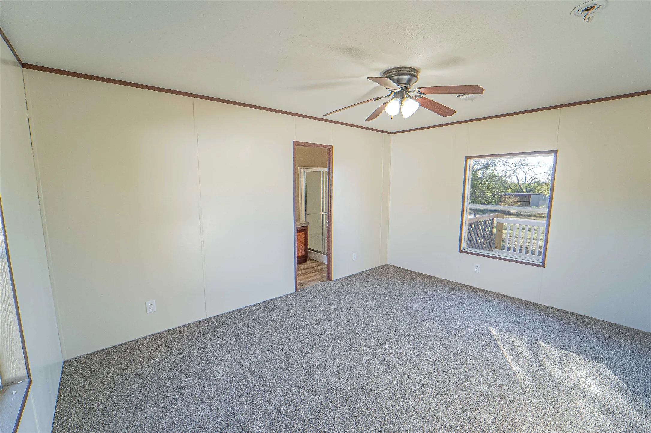 Carpeted spare room featuring ornamental molding and ceiling fan