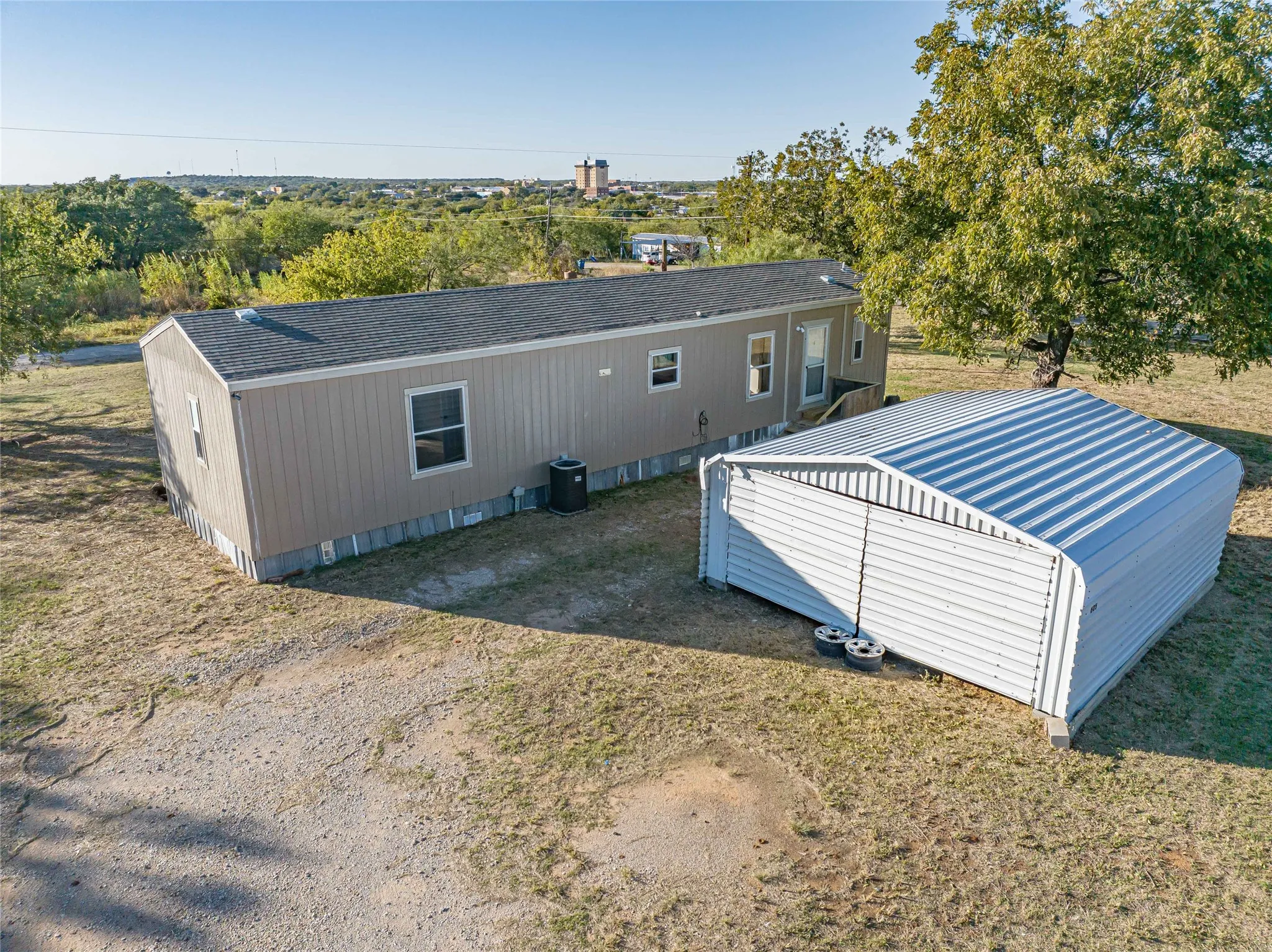 Rear view of property with an outbuilding and roof with shingles