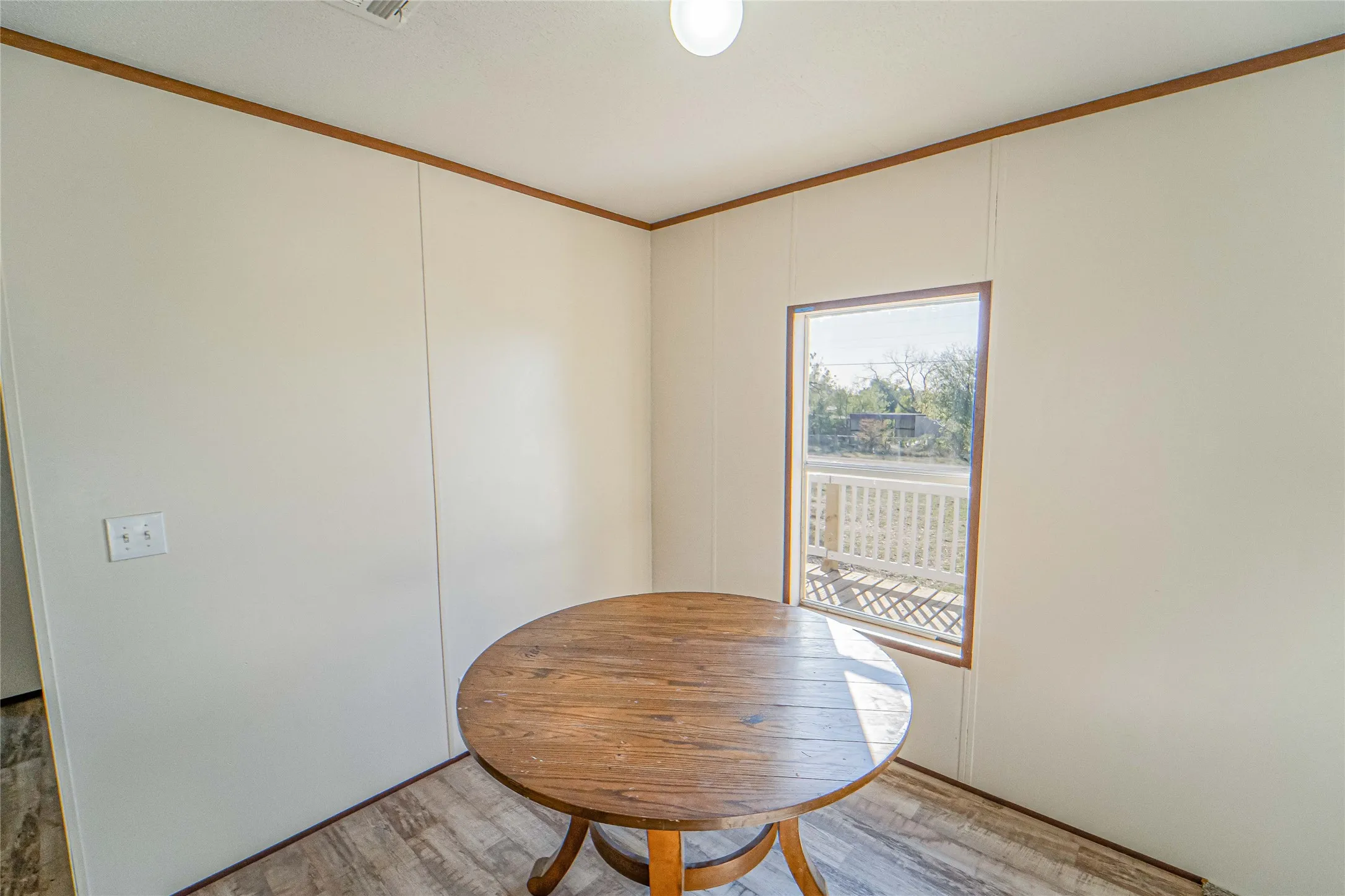 Dining room with crown molding and light wood finished floors