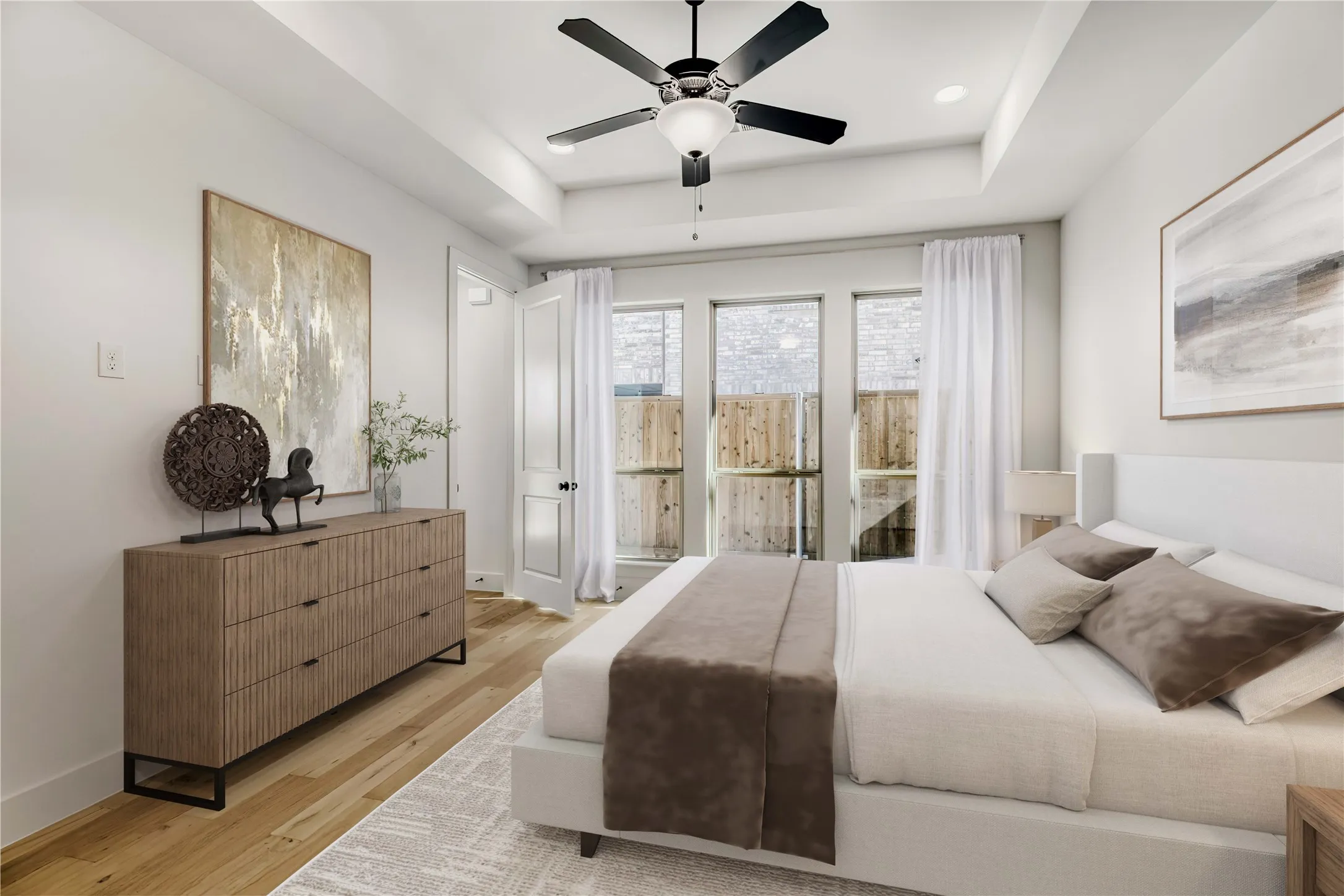 VIRTUALLY STAGED PHOTO - Bedroom featuring wood-finish flooring, a tray ceiling, and a ceiling fan with integrated lighting