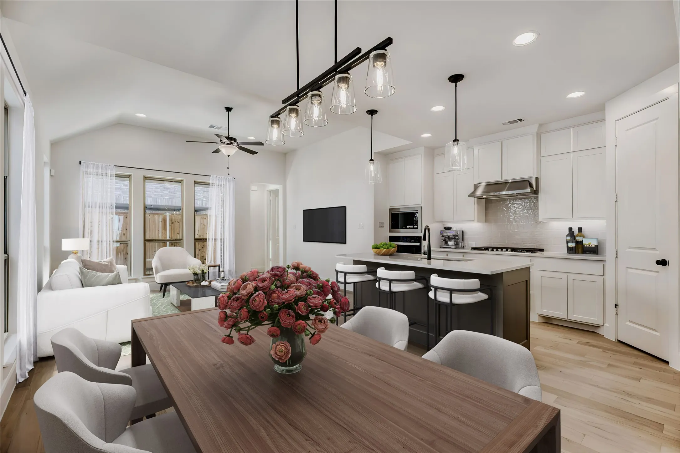 VIRTUALLY STAGED PHOTO - Open-concept living space featuring wood-finish flooring, a vaulted ceiling, and recessed lighting
