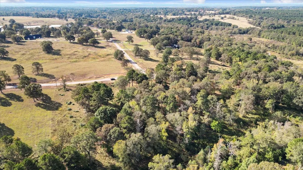 Aerial view of property and surrounding area featuring a heavily wooded area