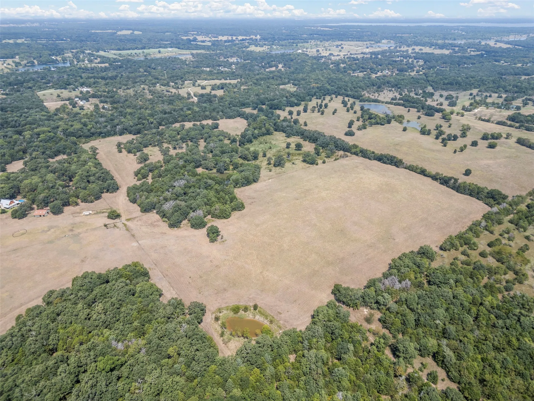 Aerial overview of property's location with a heavily wooded area