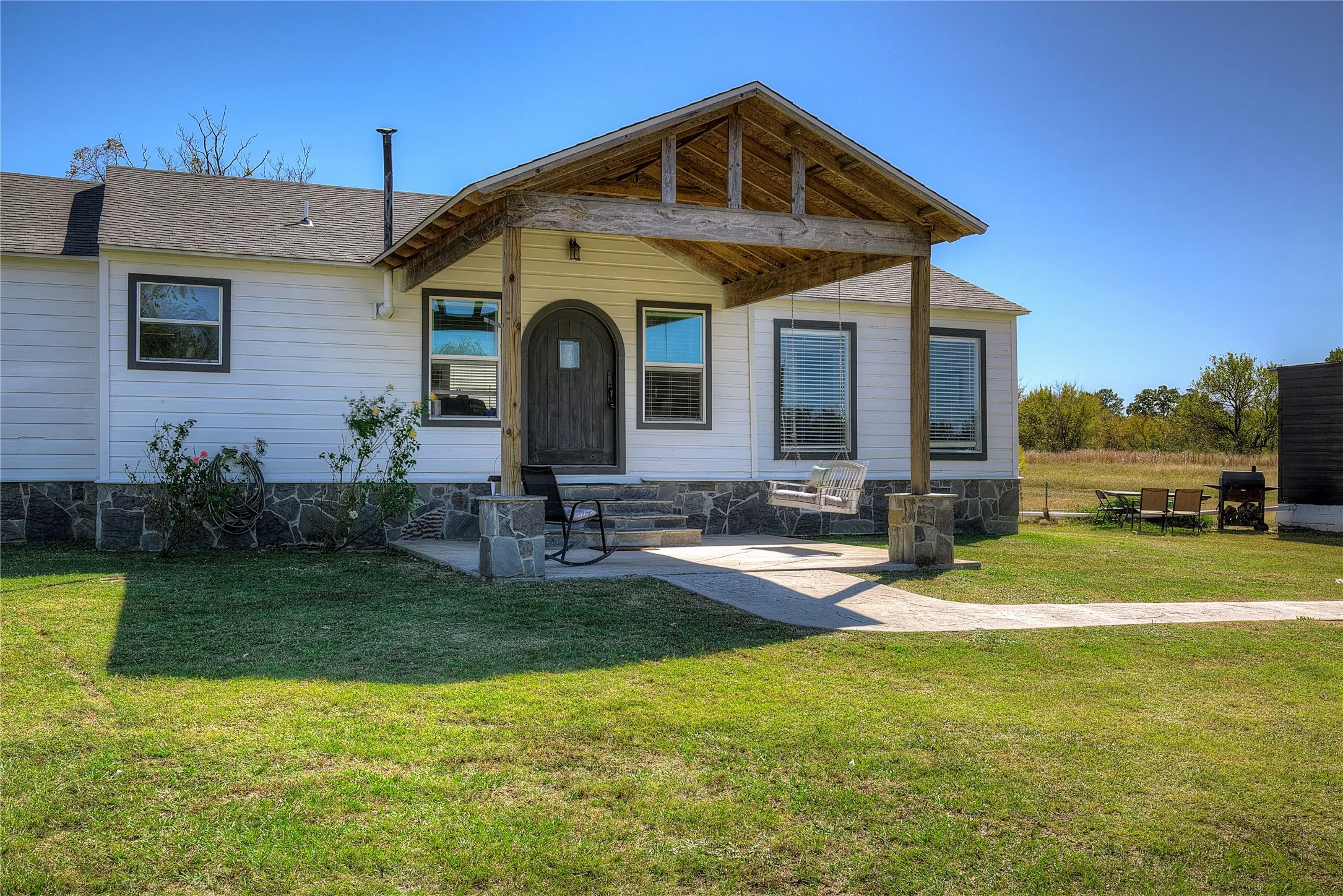 Great covered front porch with flagstone steps lead to a custom rounded entry door.
