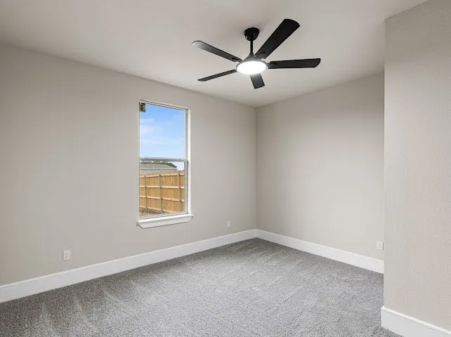 Empty room featuring light colored carpet and a ceiling fan