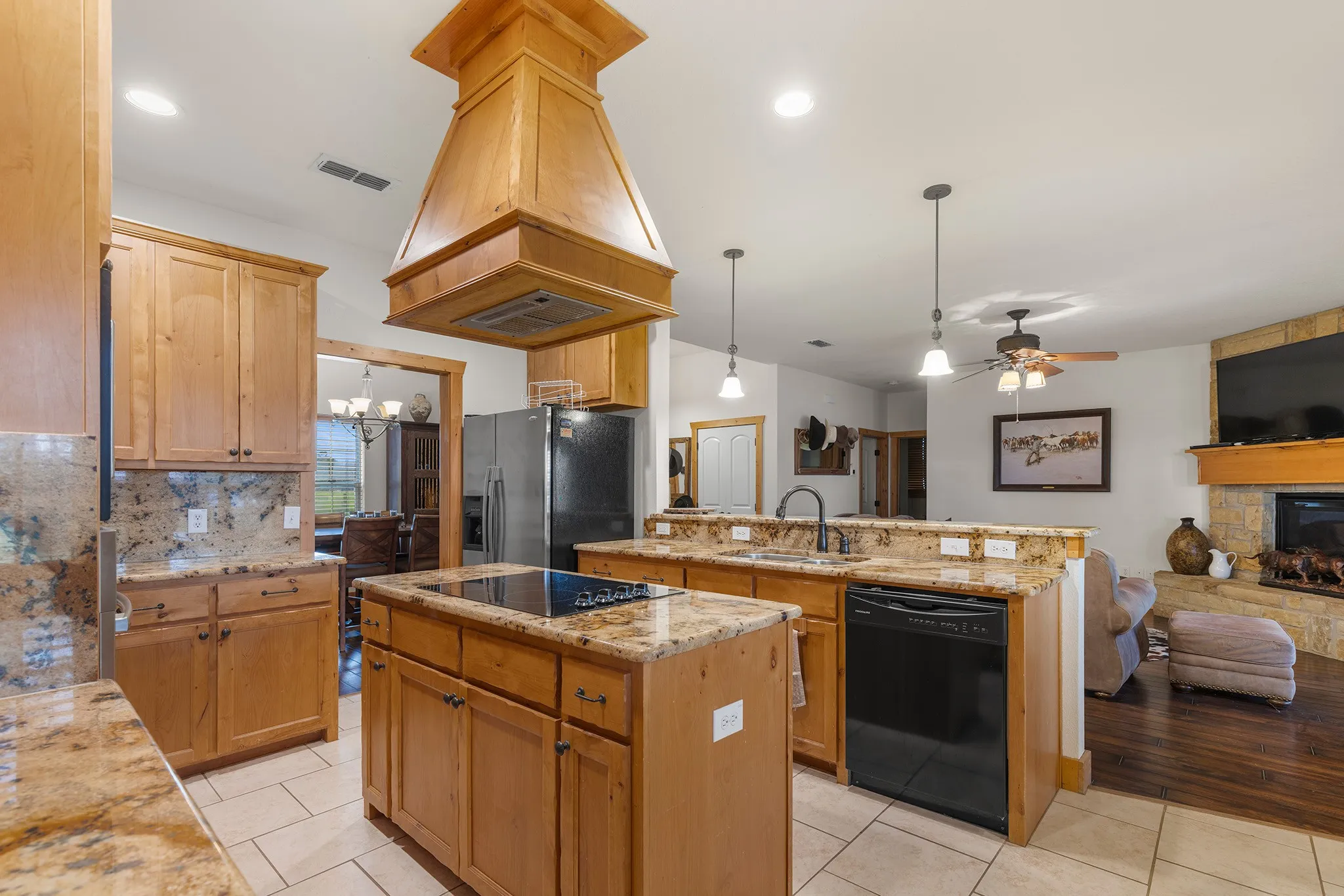 Kitchen with open floor plan, decorative backsplash, pendant lighting, and a kitchen island