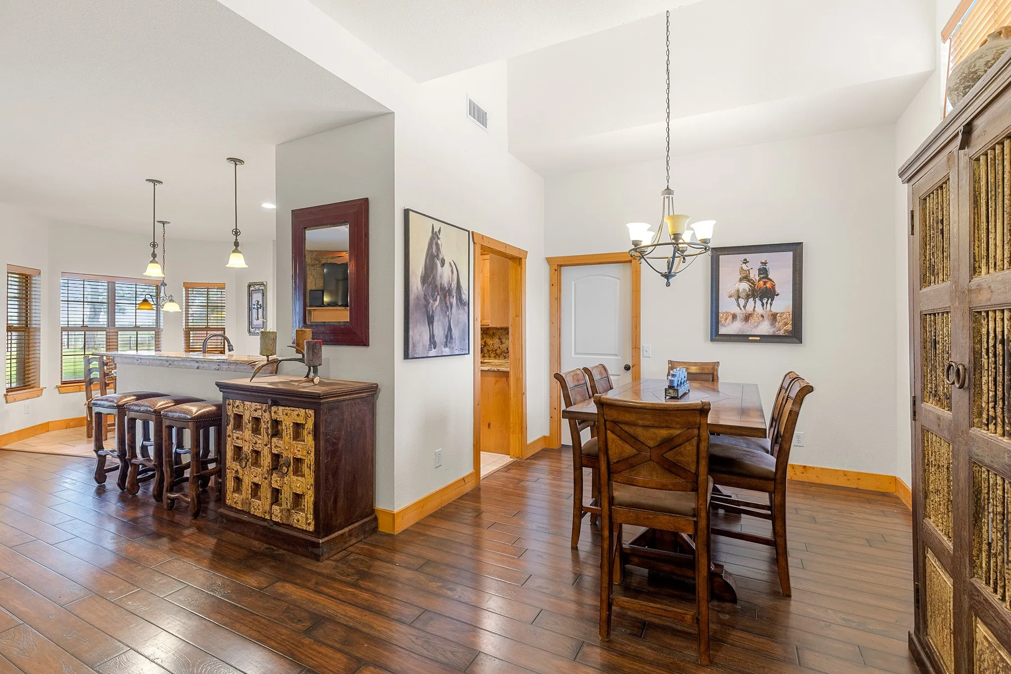 Dining space with dark wood-style floors and a chandelier