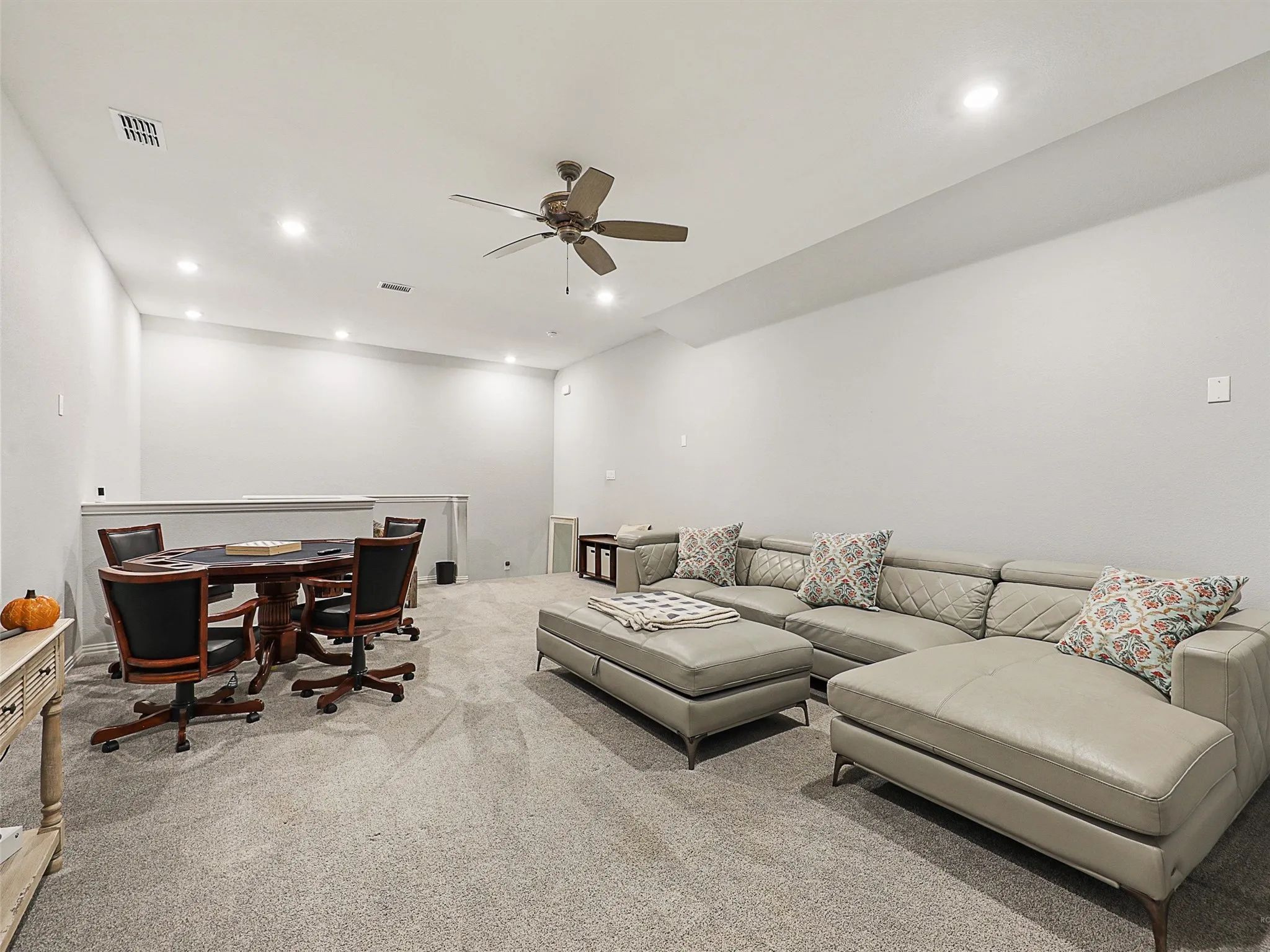 Living room with light colored carpet, recessed lighting, and ceiling fan