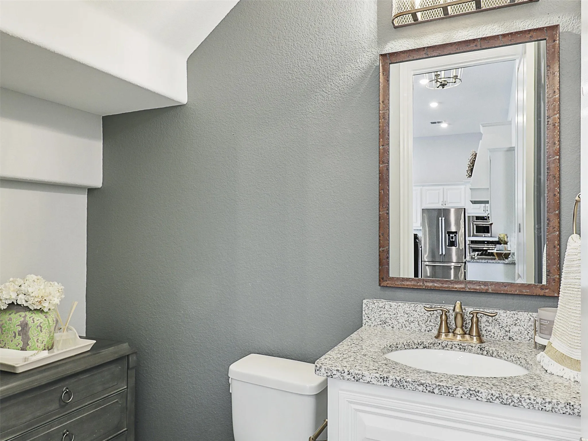 Bathroom featuring a textured wall and vanity