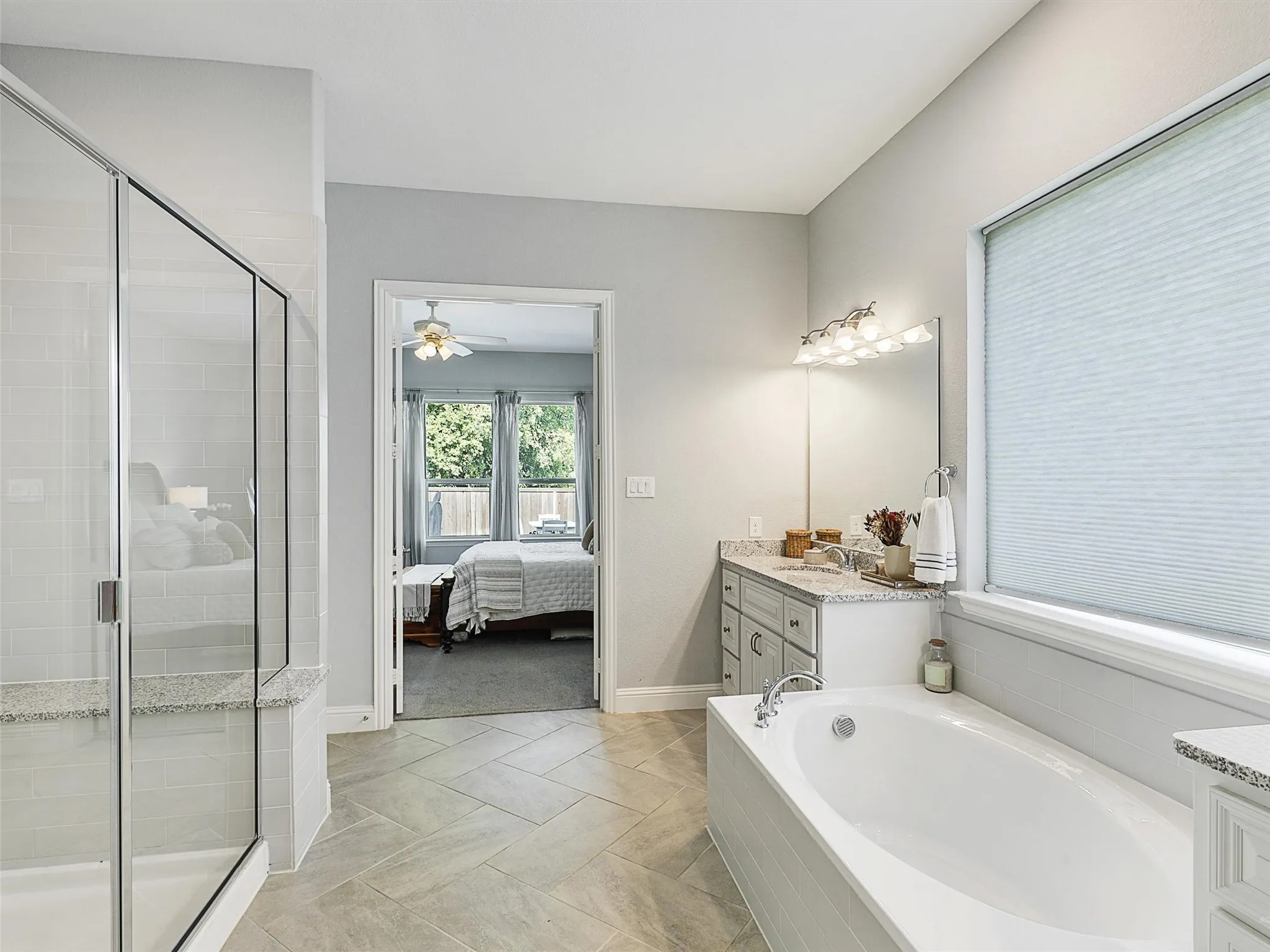 Ensuite bathroom with vanity, a bath, a stall shower, and a ceiling fan