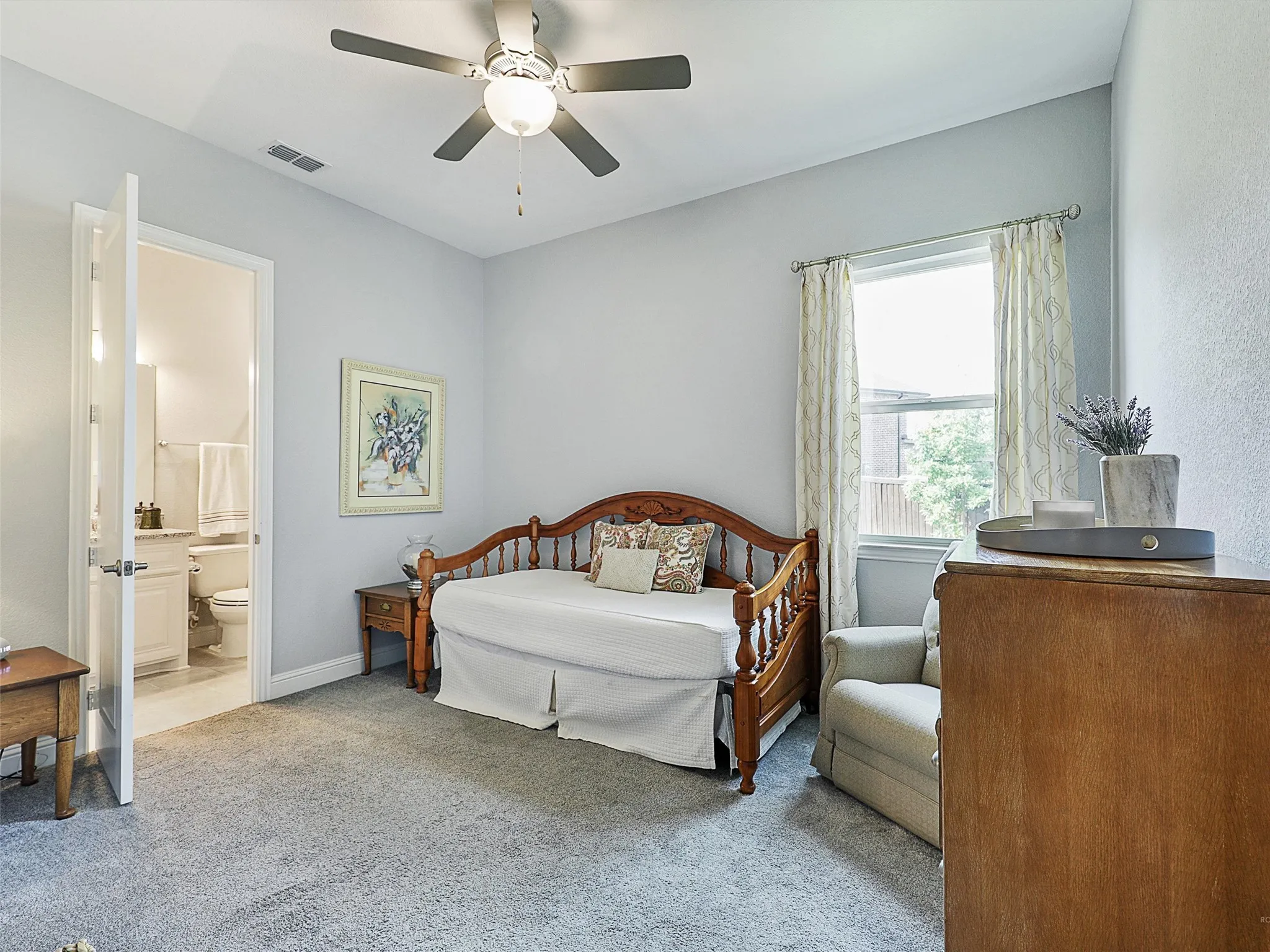 Bedroom with carpet flooring, ceiling fan, and connected bathroom