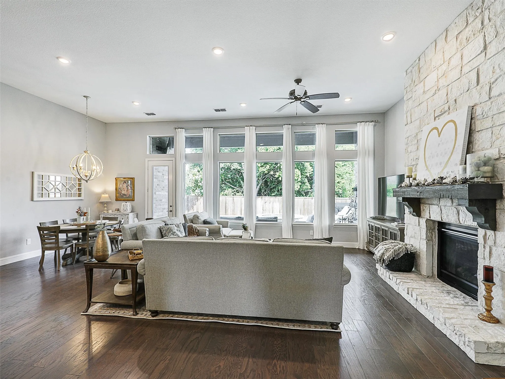 Living area featuring dark wood-style floors, plenty of natural light, a fireplace, and recessed lighting