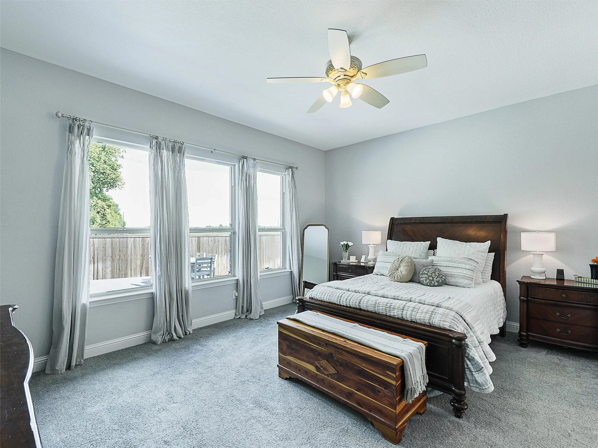 Bedroom featuring carpet floors, a ceiling fan, and multiple windows