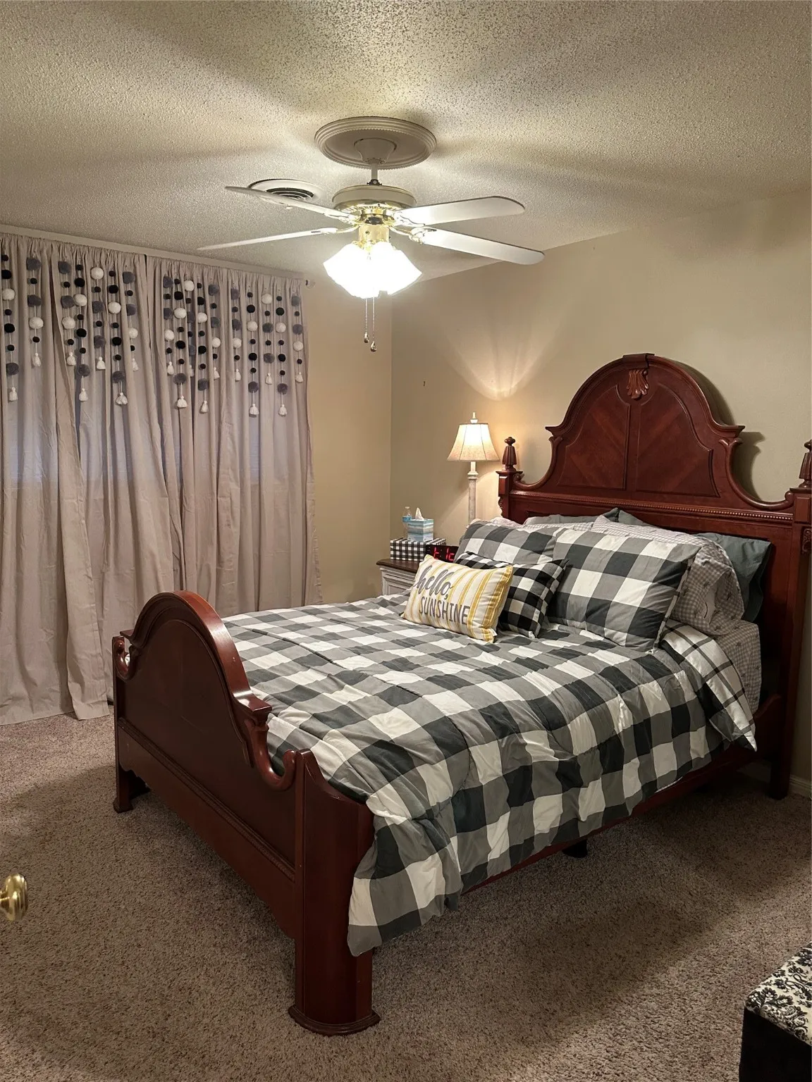 Carpeted bedroom featuring a textured ceiling and ceiling fan