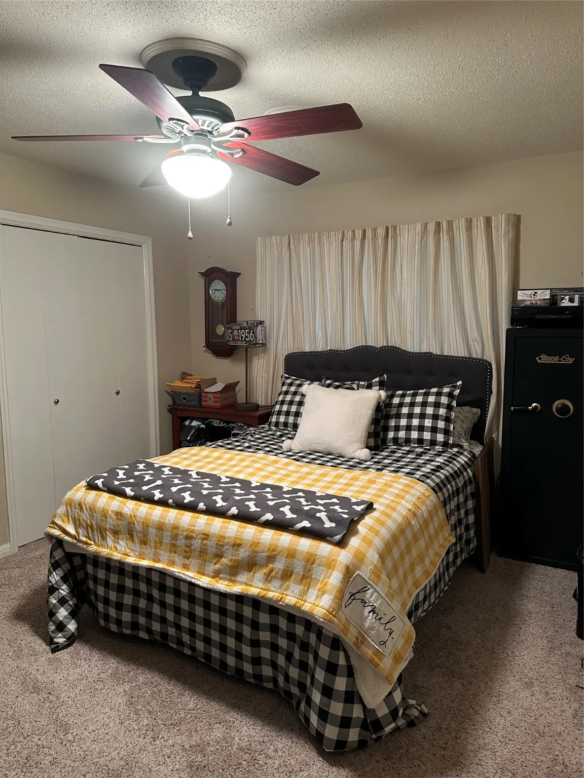 Carpeted bedroom featuring a textured ceiling, a ceiling fan, and a closet