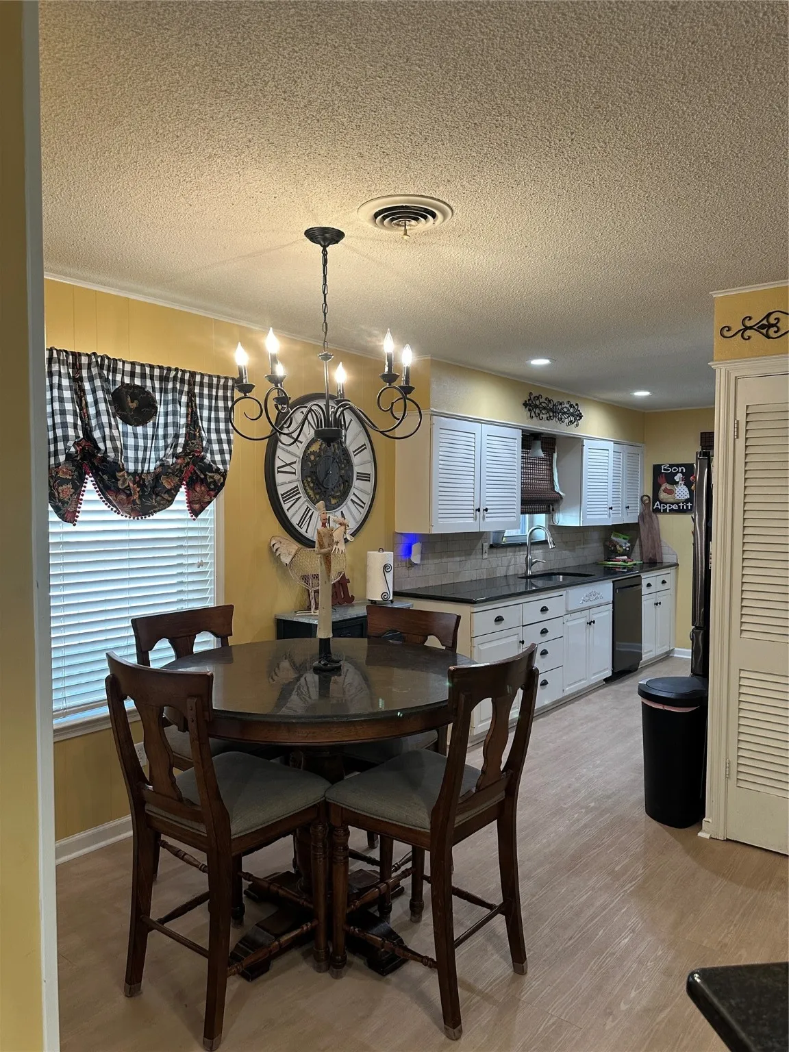 Dining room featuring a textured ceiling, light wood-type flooring, and a chandelier