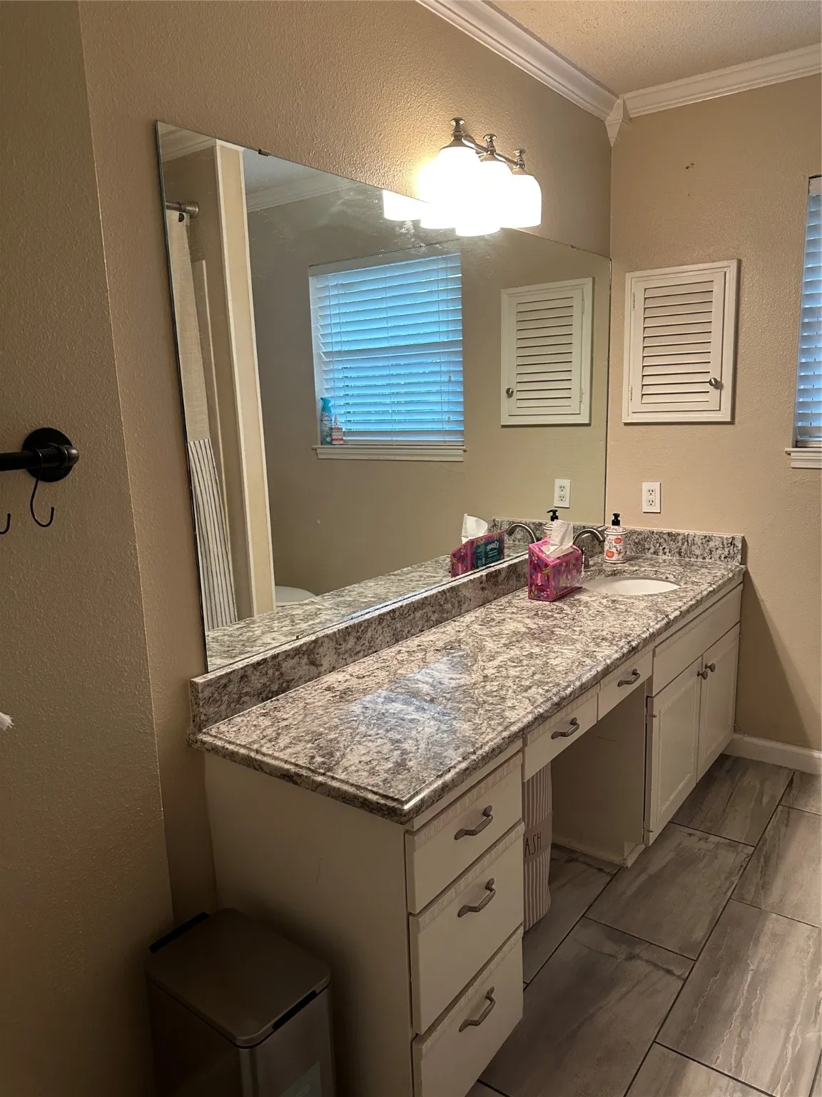 Bathroom featuring a textured wall, crown molding, vanity, a shower with curtain, and a textured ceiling