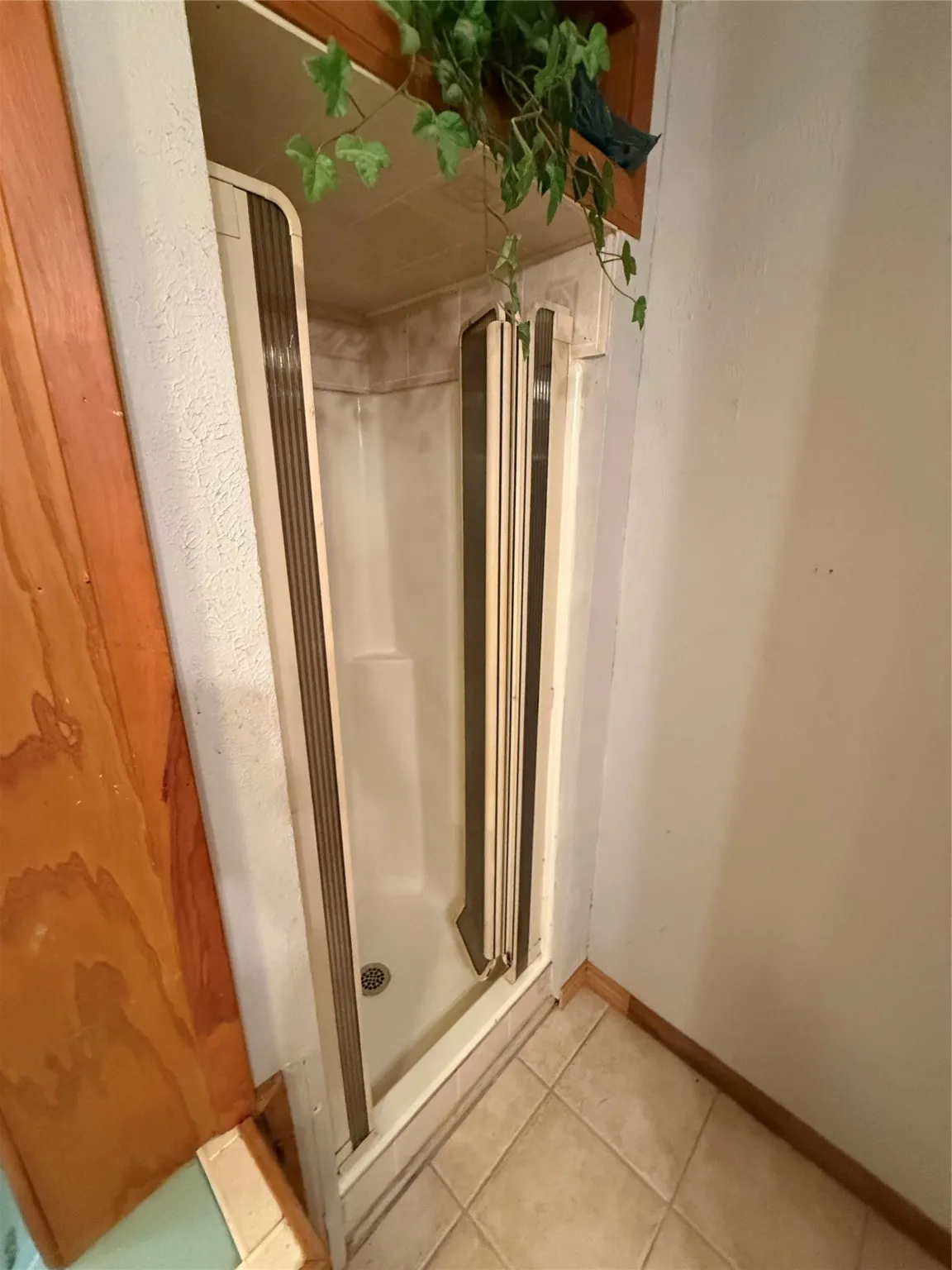 Bathroom featuring a stall shower and light tile patterned flooring