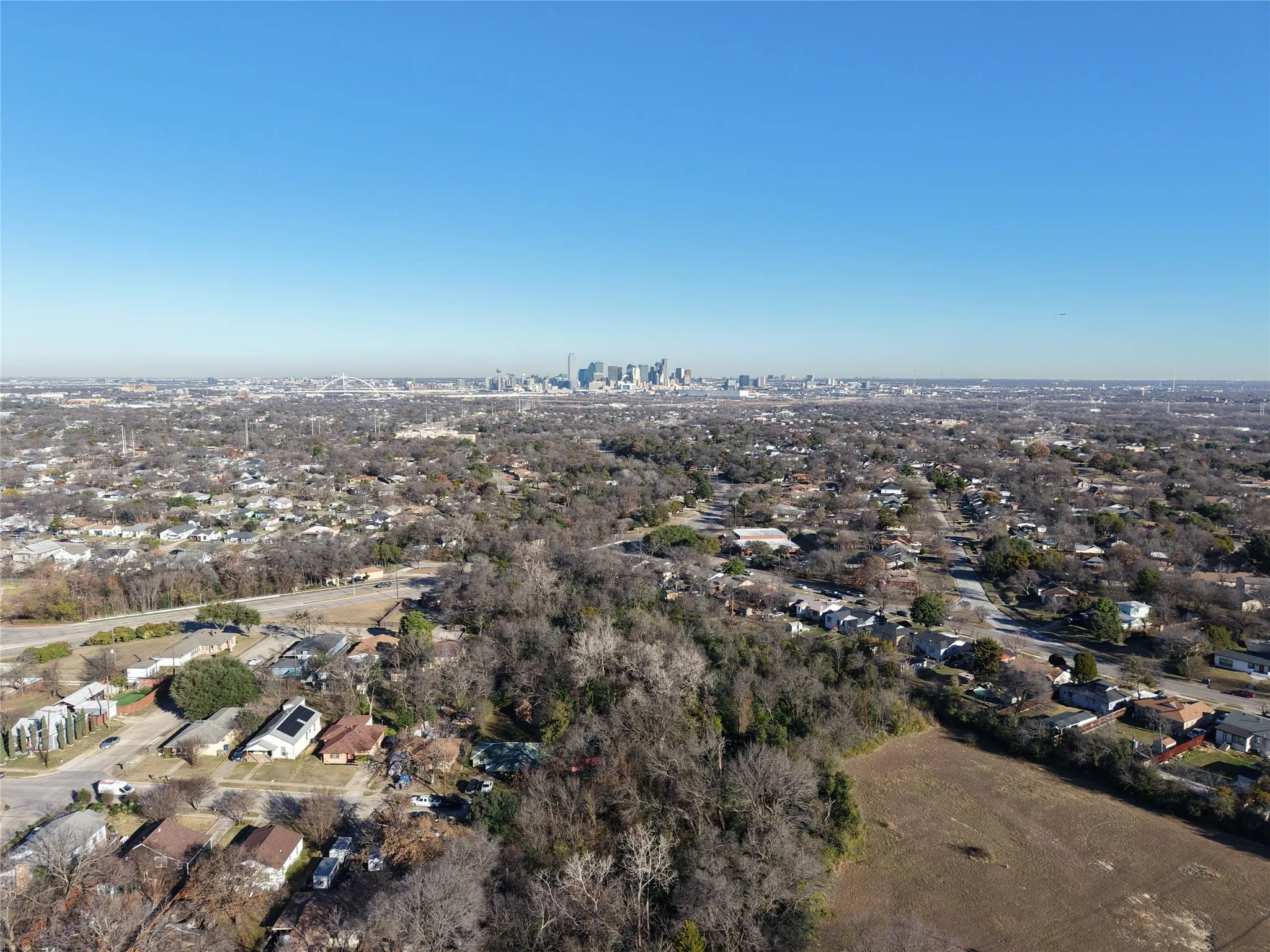 Aerial view of property and surrounding area featuring nearby suburban area and skyline