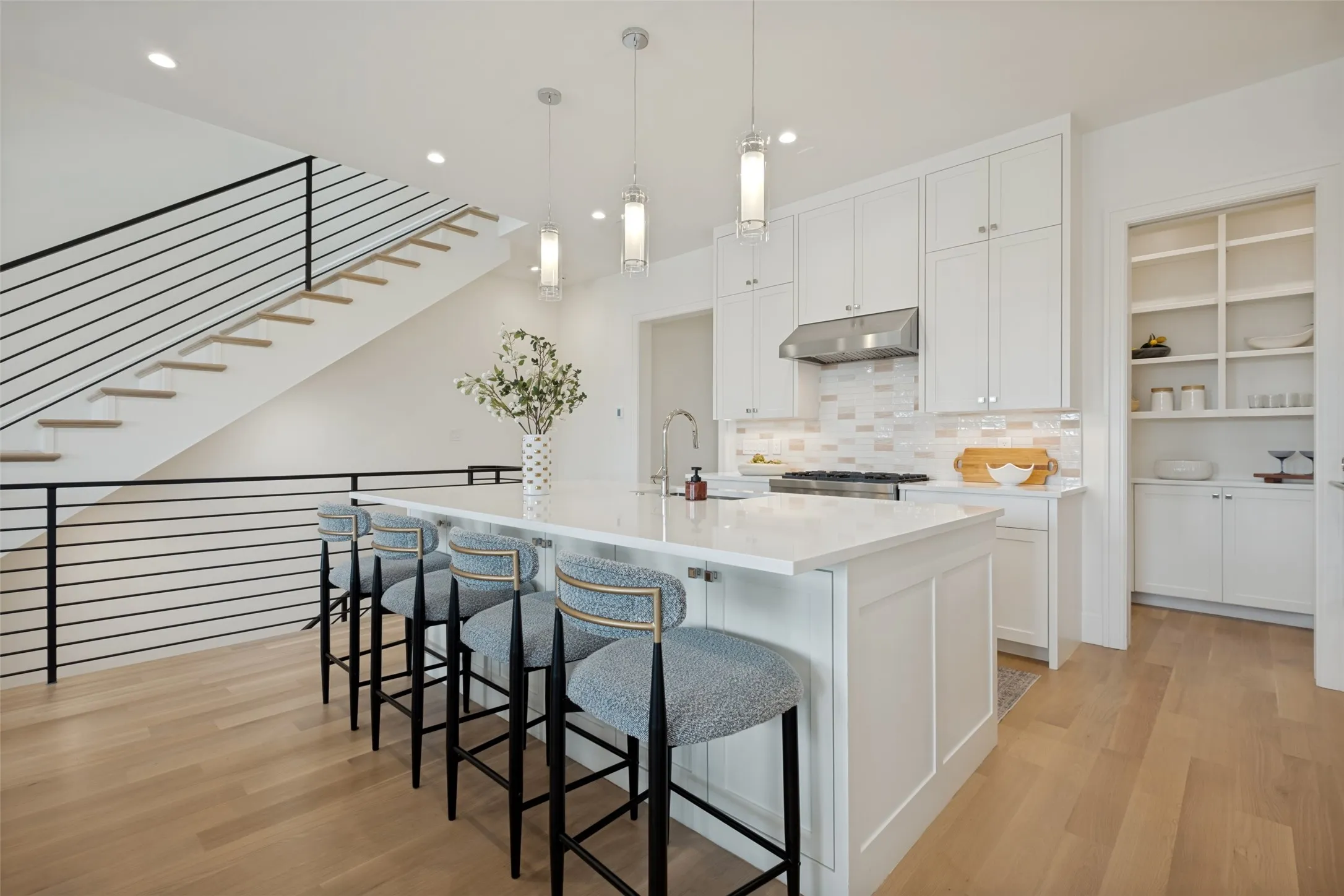 Spacious kitchen featuring an island with breakfast bar seating and a large walk-in pantry for extra storage.