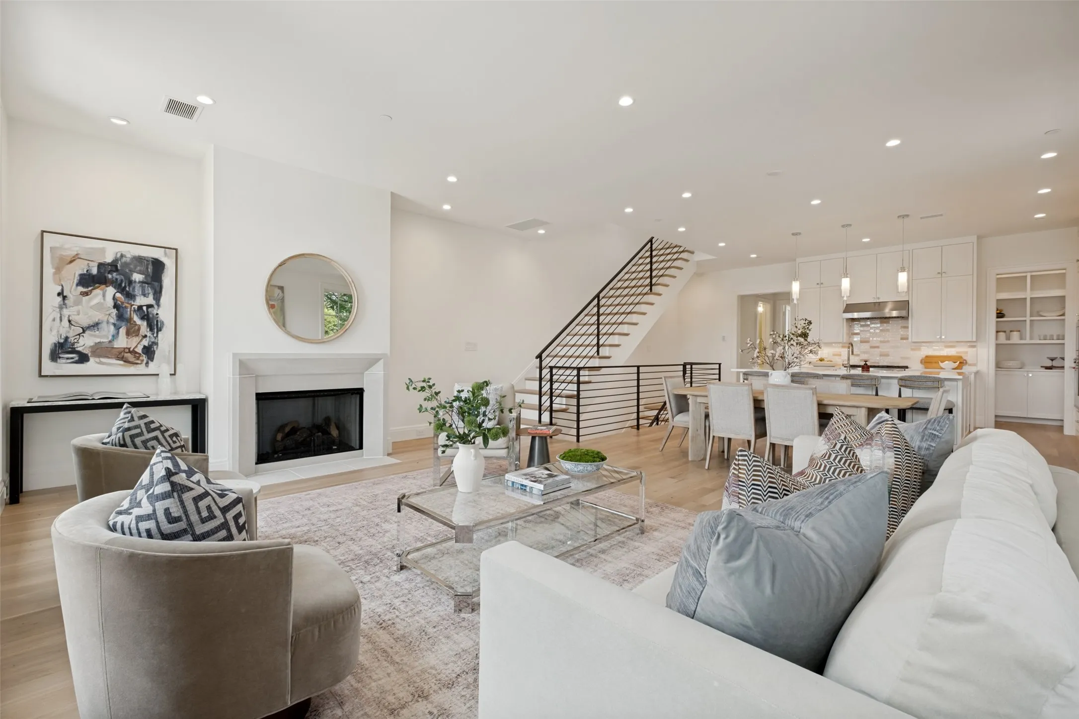 The spacious second floor is the heart of the home, featuring a centrally located living area with a fireplace, dining space, kitchen with pantry, powder room, and primary suite.