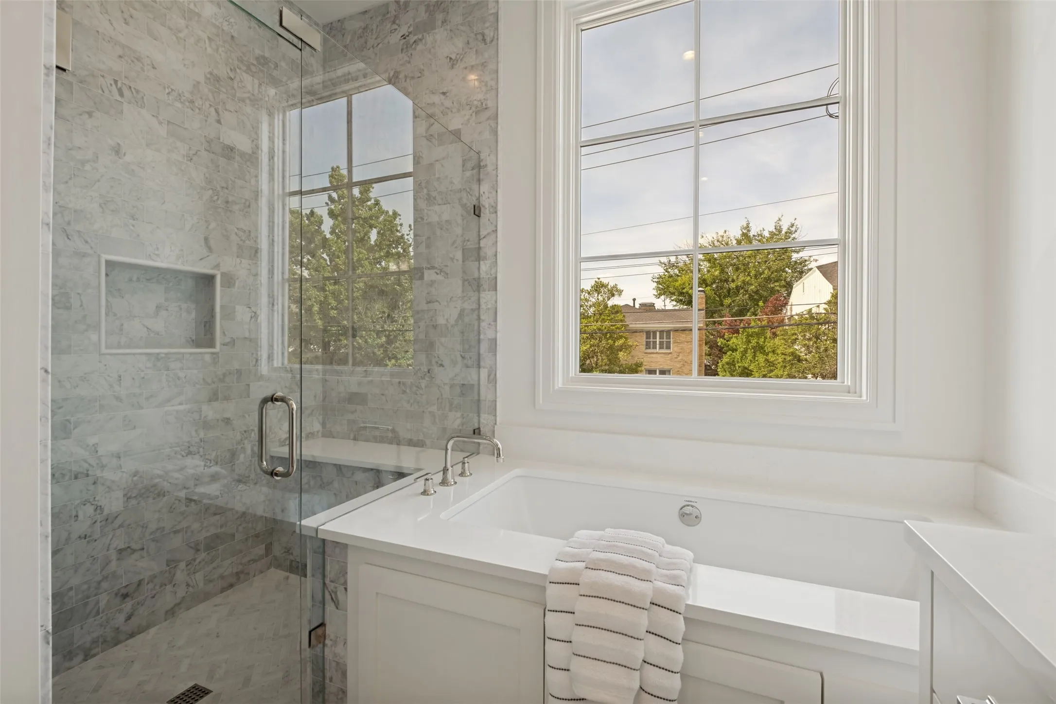 Exquisite primary bathroom featuring a separate shower and tub, premium marble finishes, and designer detail.