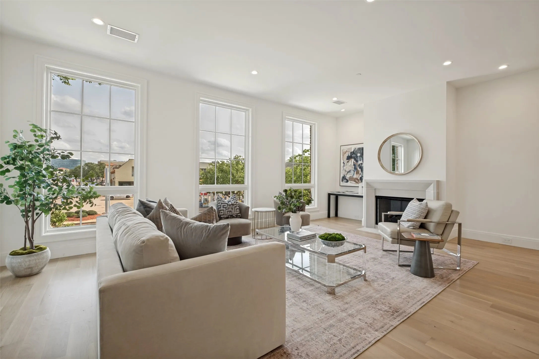 Living room featuring a central fireplace and treetop views from the second floor.