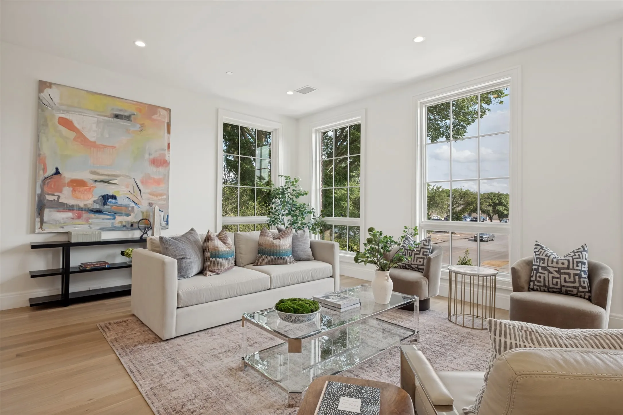 Spacious living area featuring beautiful wide-plank flooring and abundant natural light, perfect for relaxing or entertaining guests.