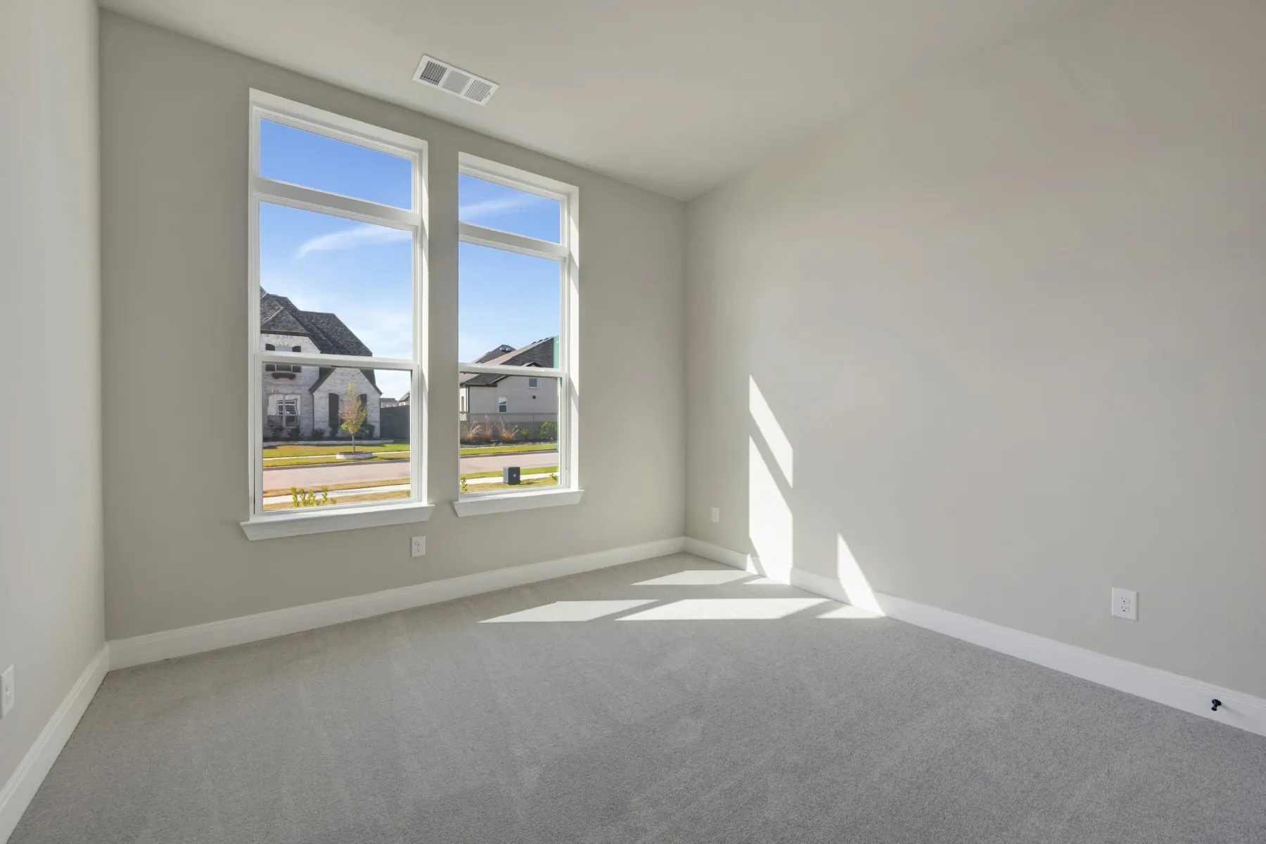 Spare room featuring light carpet and baseboards