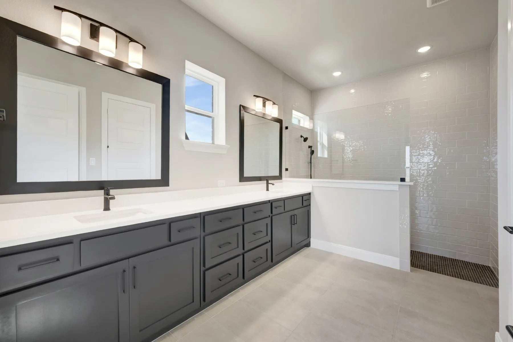 Bathroom with double vanity, walk in shower, recessed lighting, and light tile patterned flooring