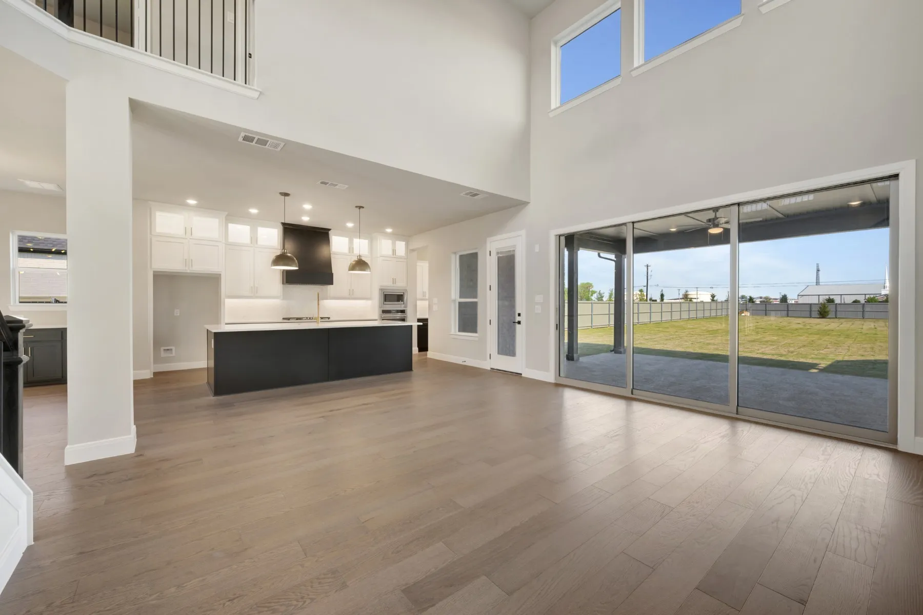 Unfurnished living room featuring dark wood-style flooring, a high ceiling, and recessed lighting