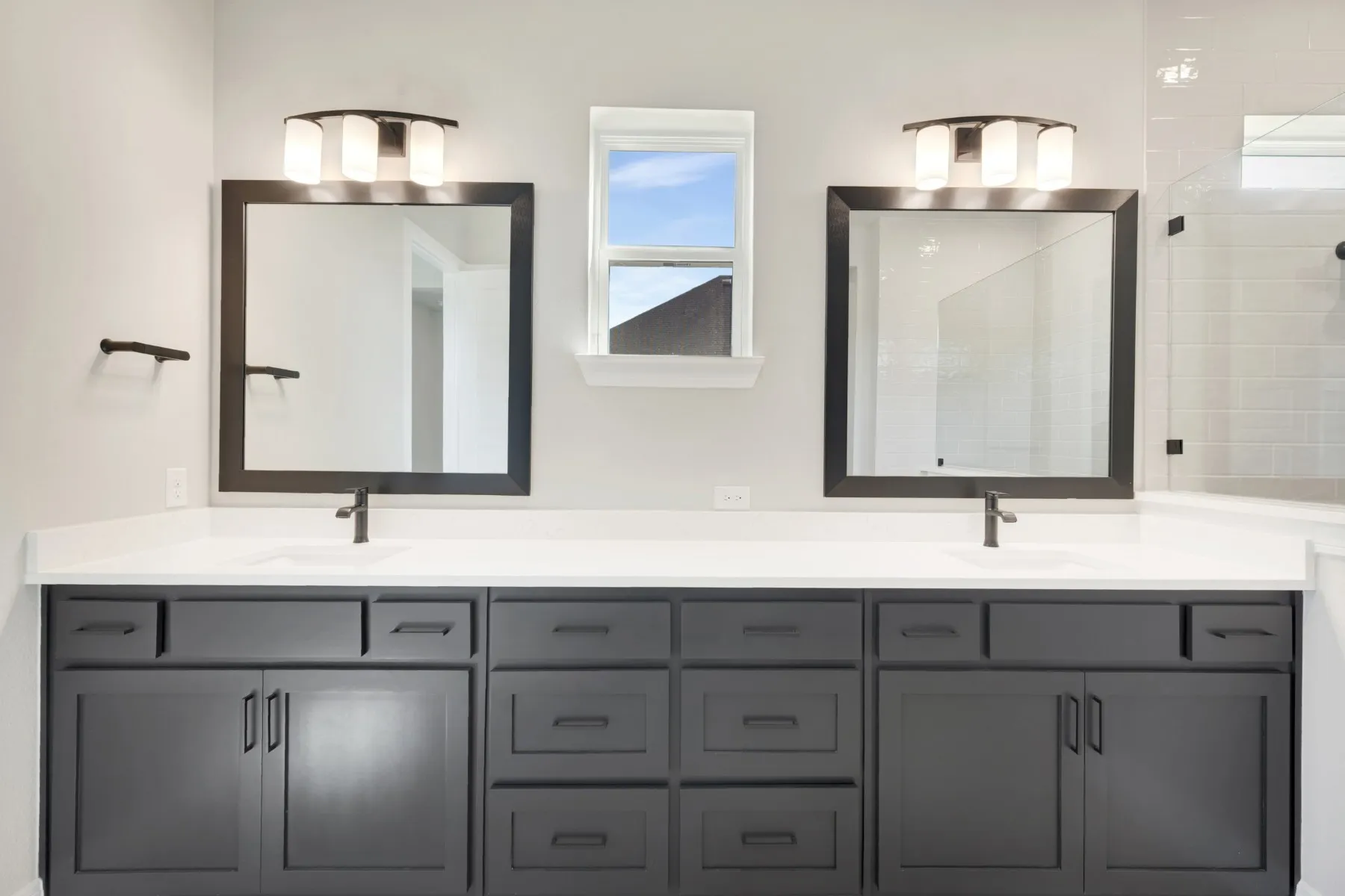 Full bathroom with double vanity and a shower stall