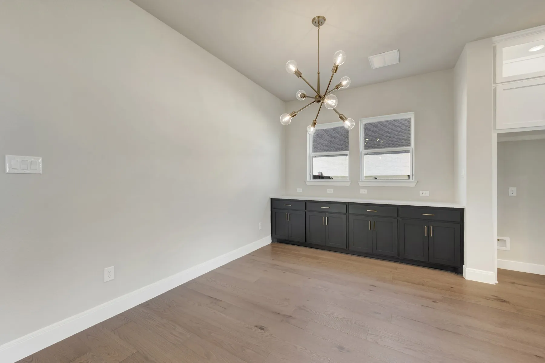 Unfurnished dining area with light wood finished floors, a chandelier, and lofted ceiling