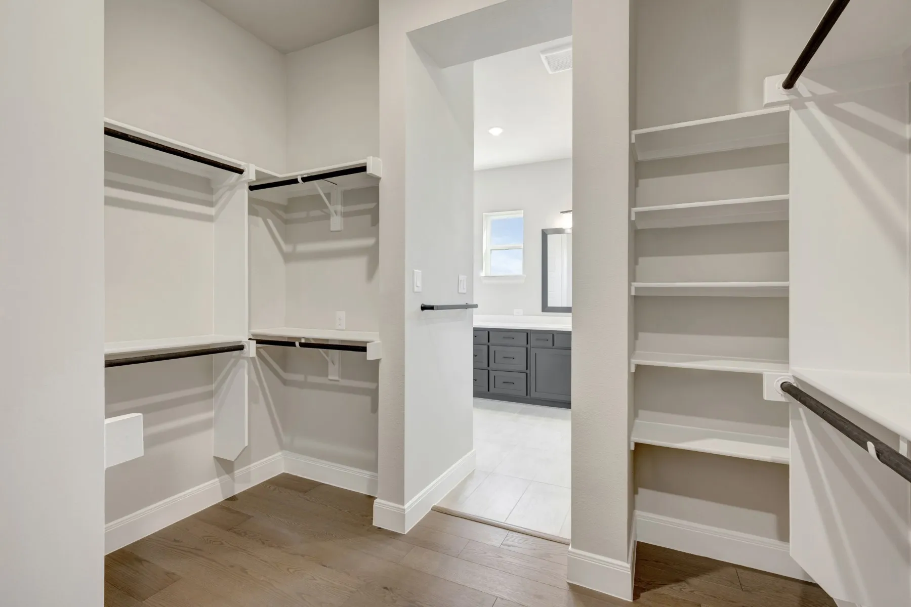 Walk in closet with light wood-style floors