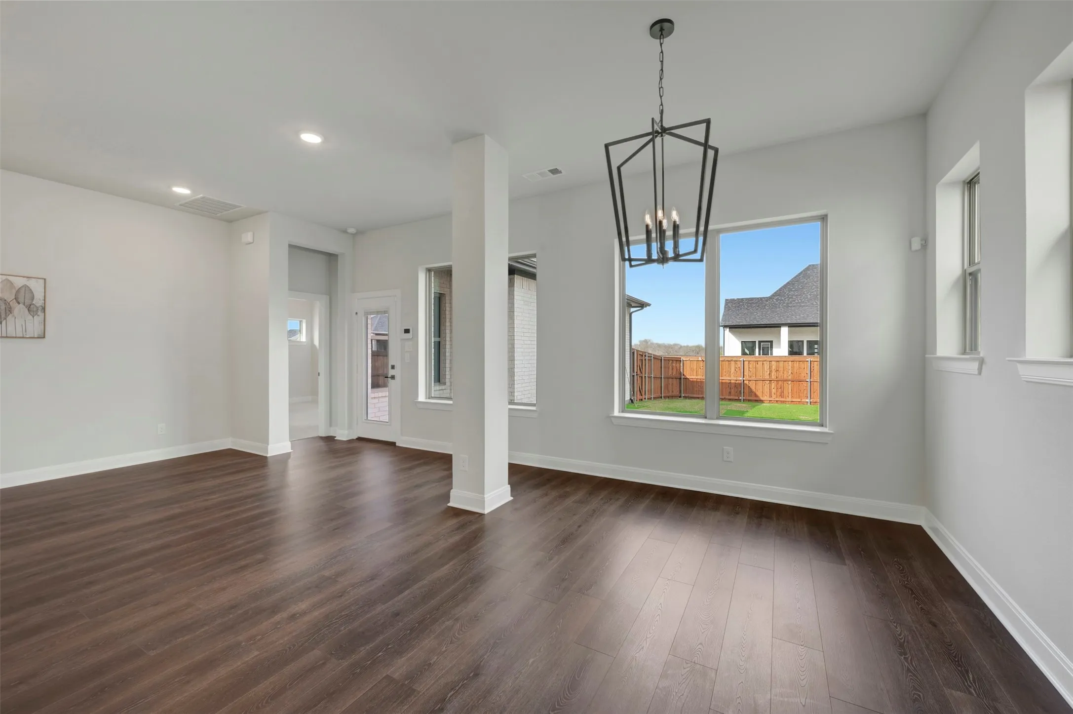 Unfurnished dining area with a chandelier and dark wood finished floors