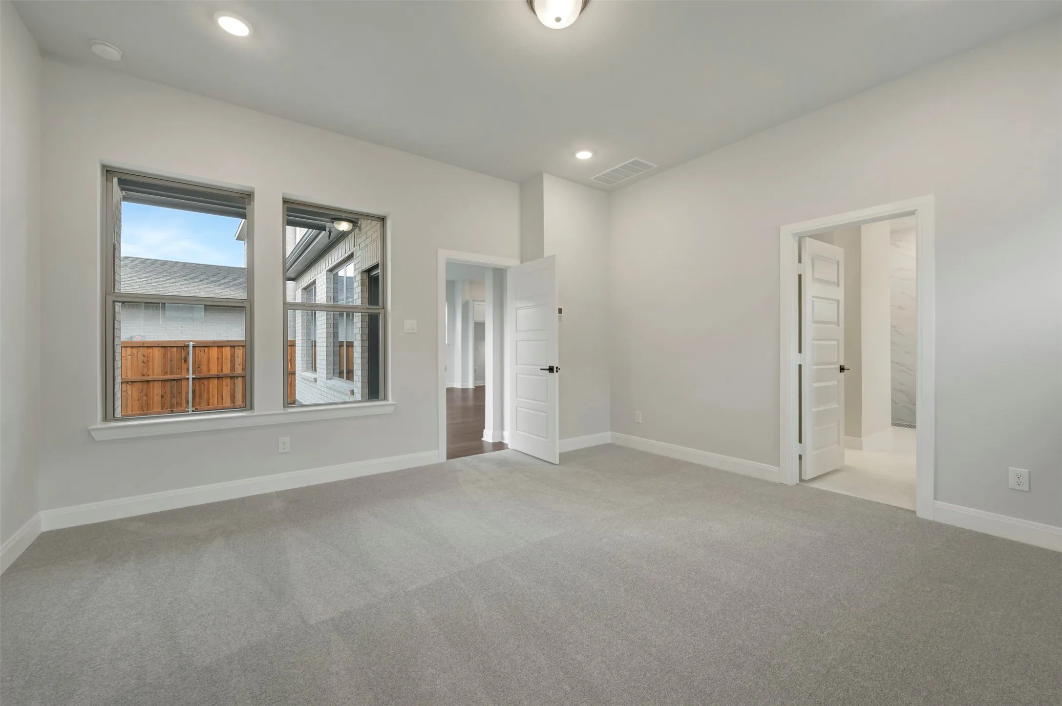Unfurnished bedroom with light colored carpet and recessed lighting